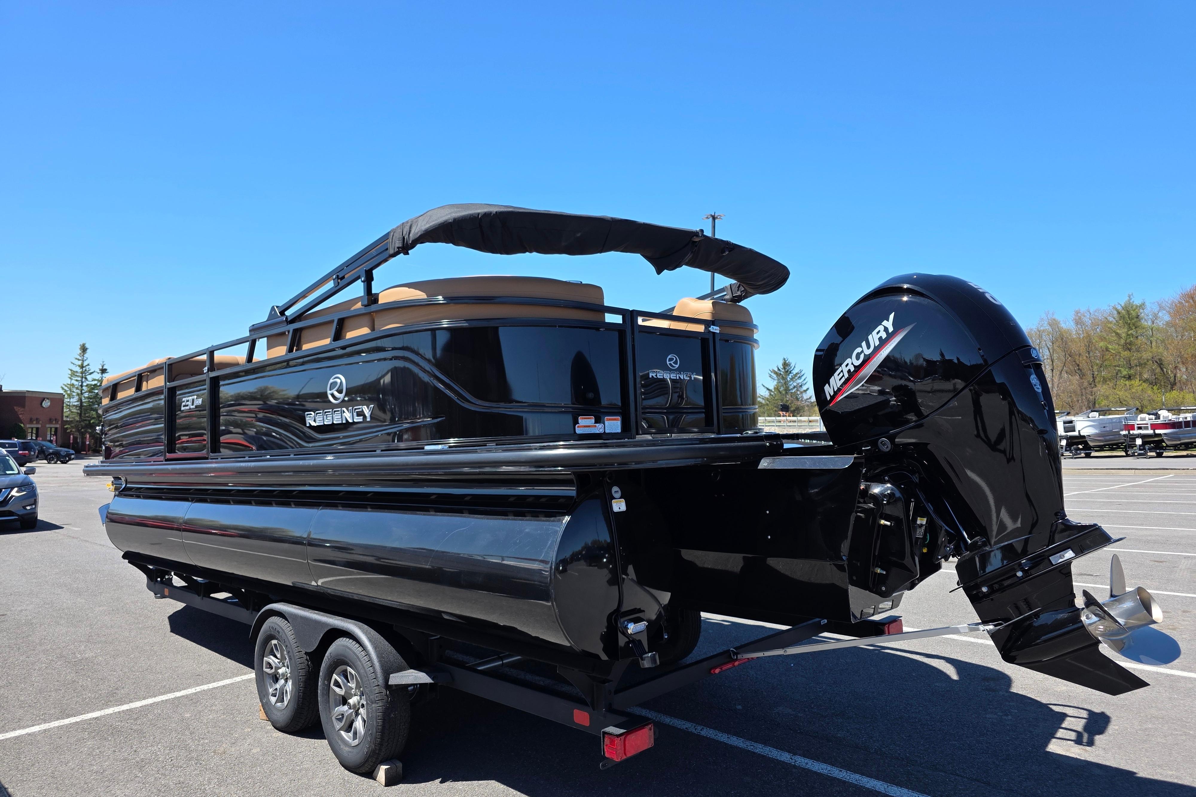 2026 Regency 230 DL pontoon boat with Mercury engine in parking lot.