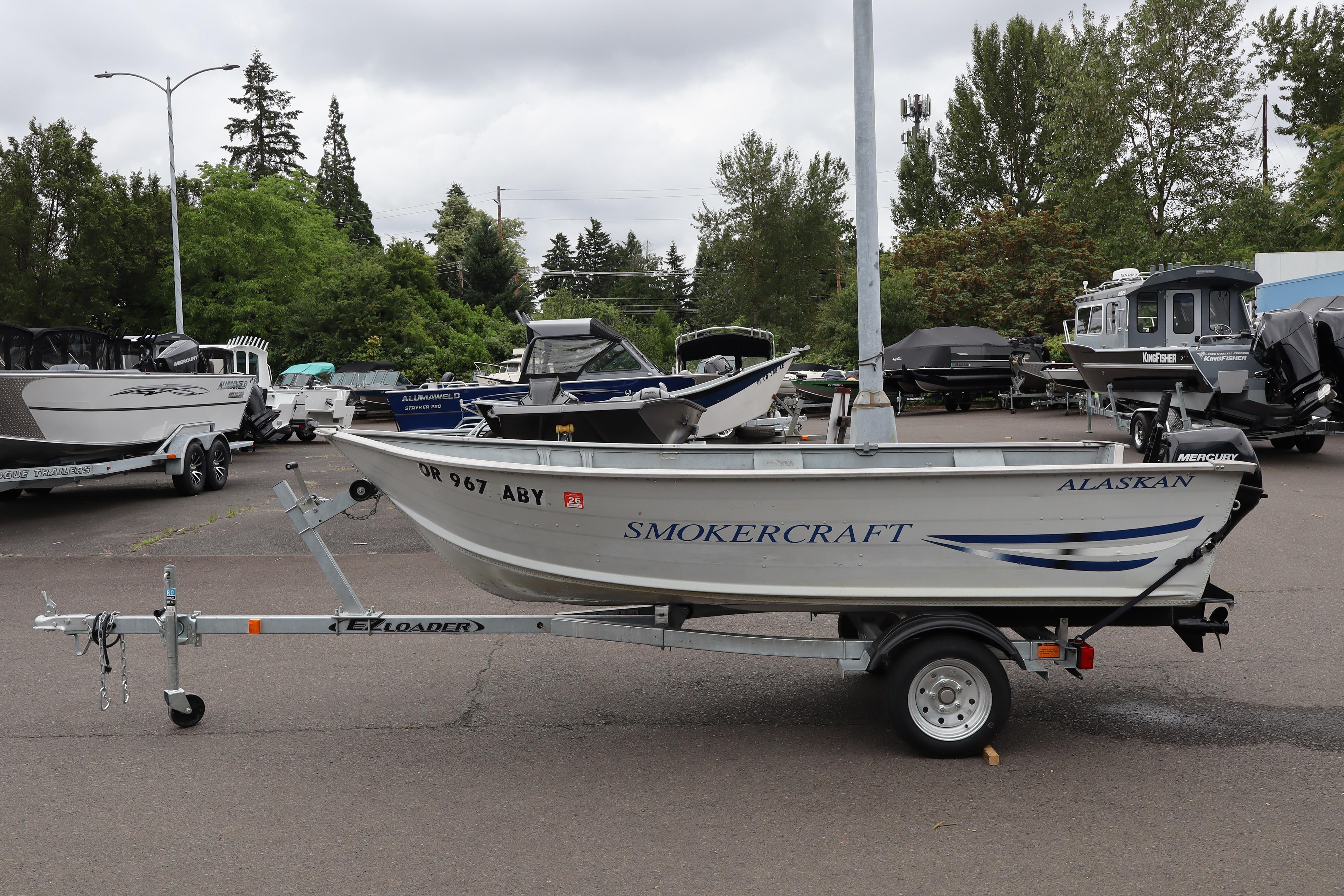 2003 Smoker Craft Alaskan 13 boat on trailer in outdoor dealership setting.
