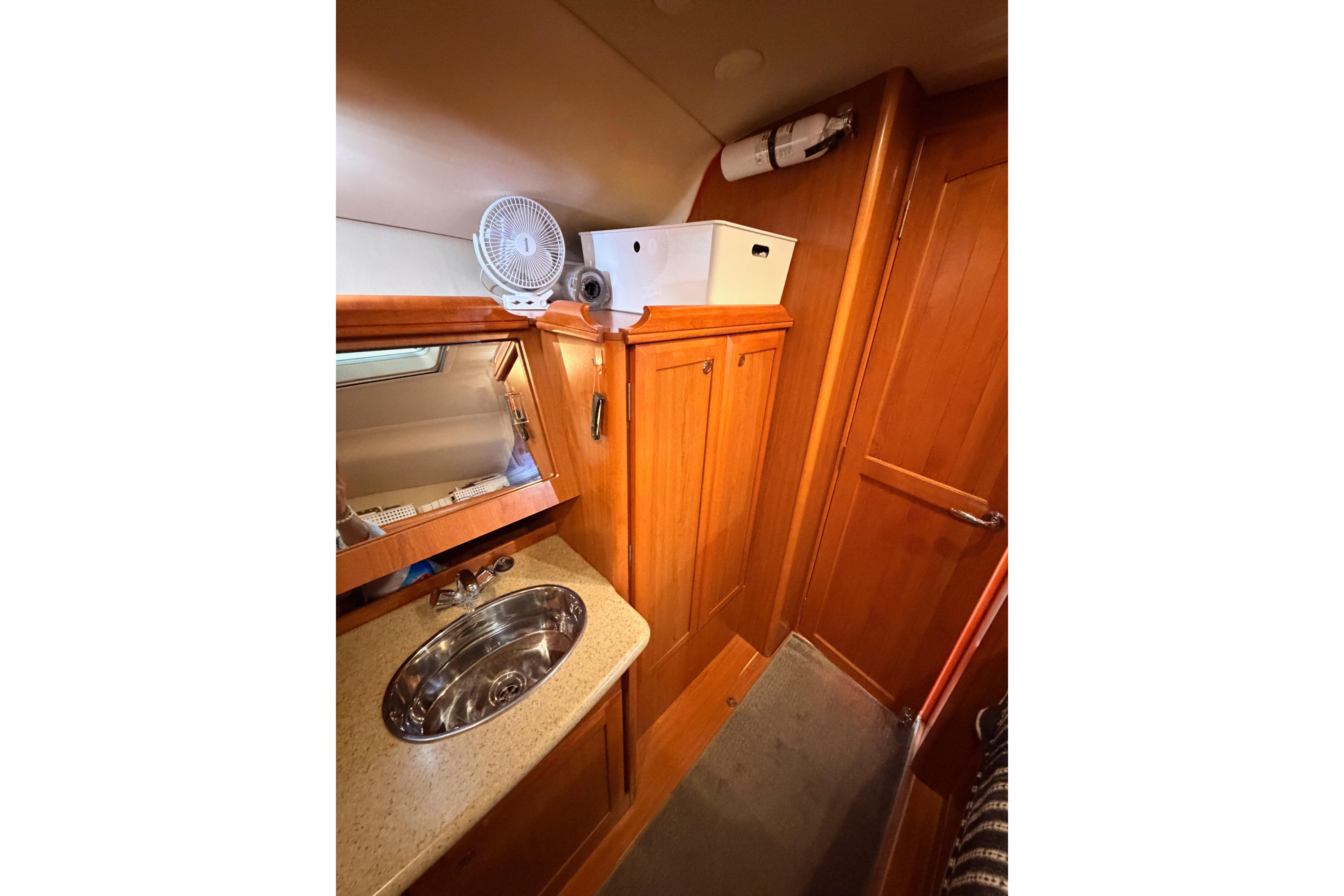 Interior of 2008 Hunter 45 Deck Salon, featuring wooden cabinetry and a compact sink area.