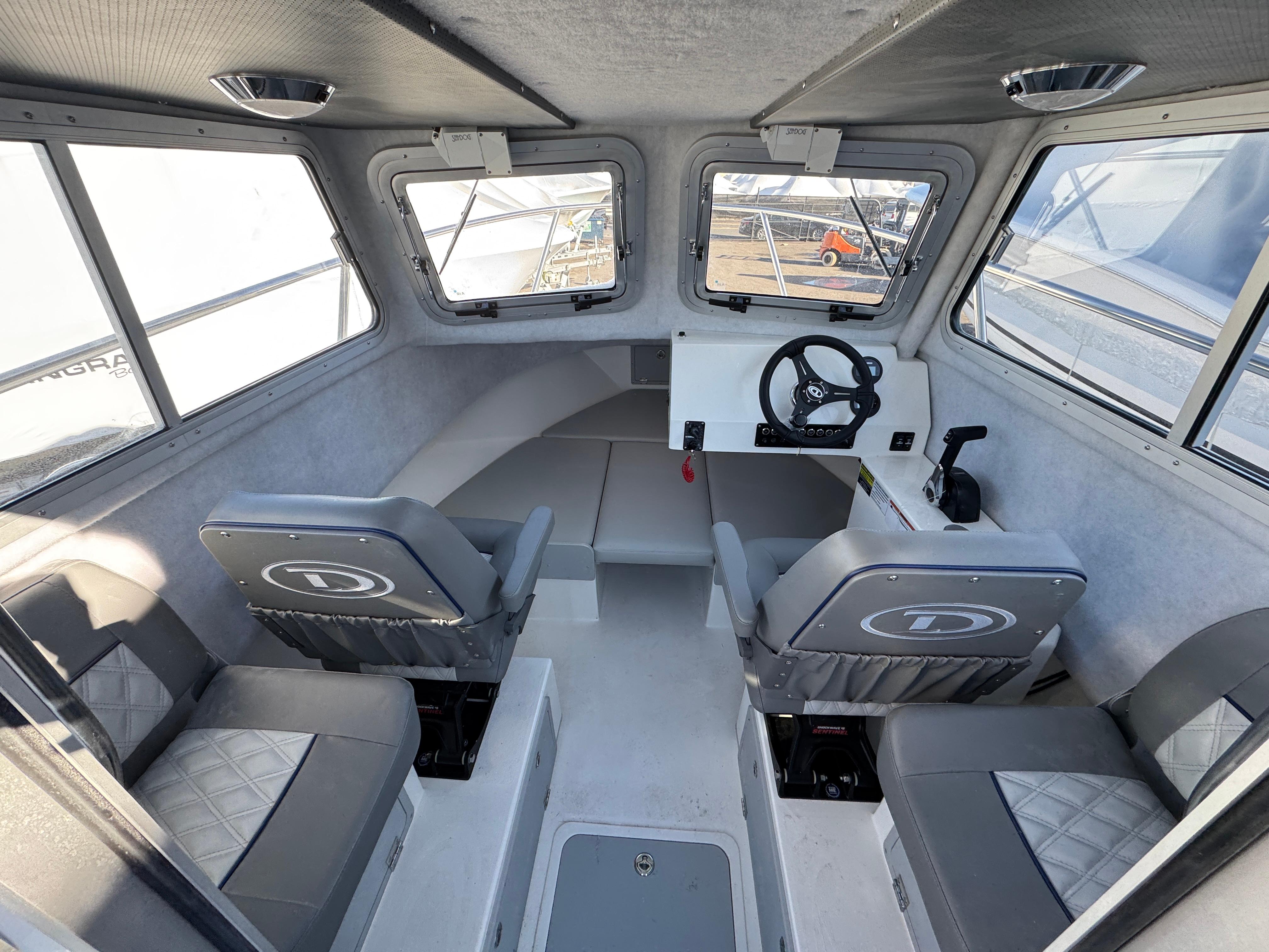 Interior of 2025 Defiance Admiral 220 EX boat, featuring seating and steering console.
