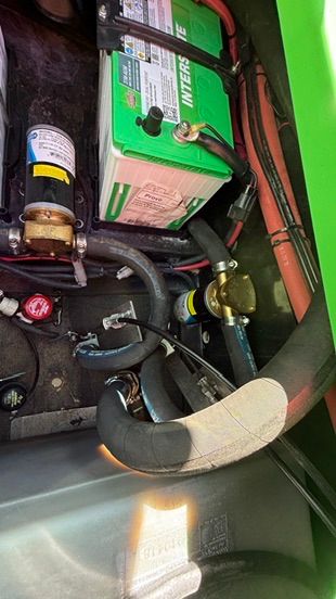 Battery and hoses in a boat's engine compartment.