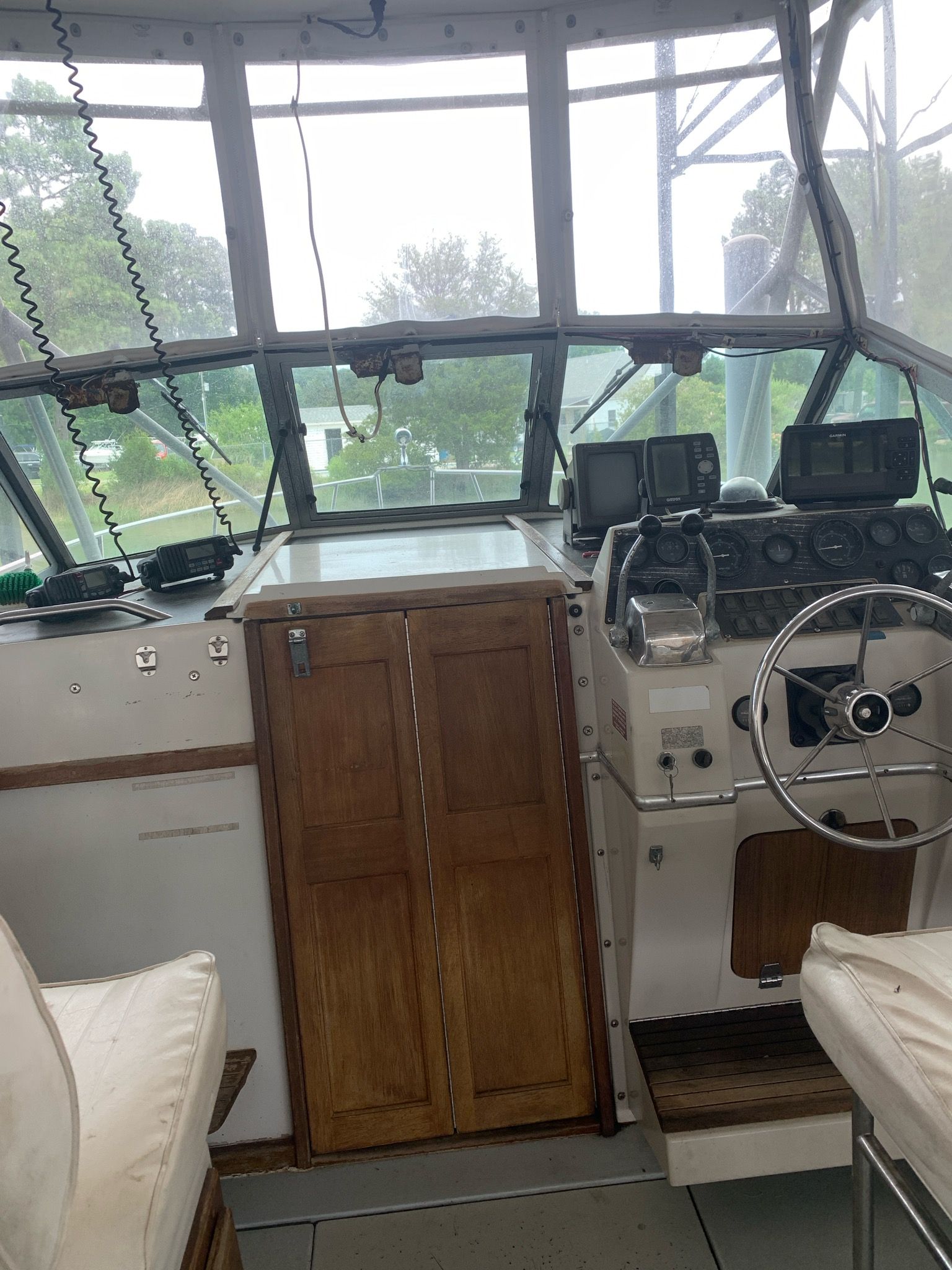 The image shows the cockpit of a 1987 Wellcraft COASTAL boat with wooden cabinets and a steering console.