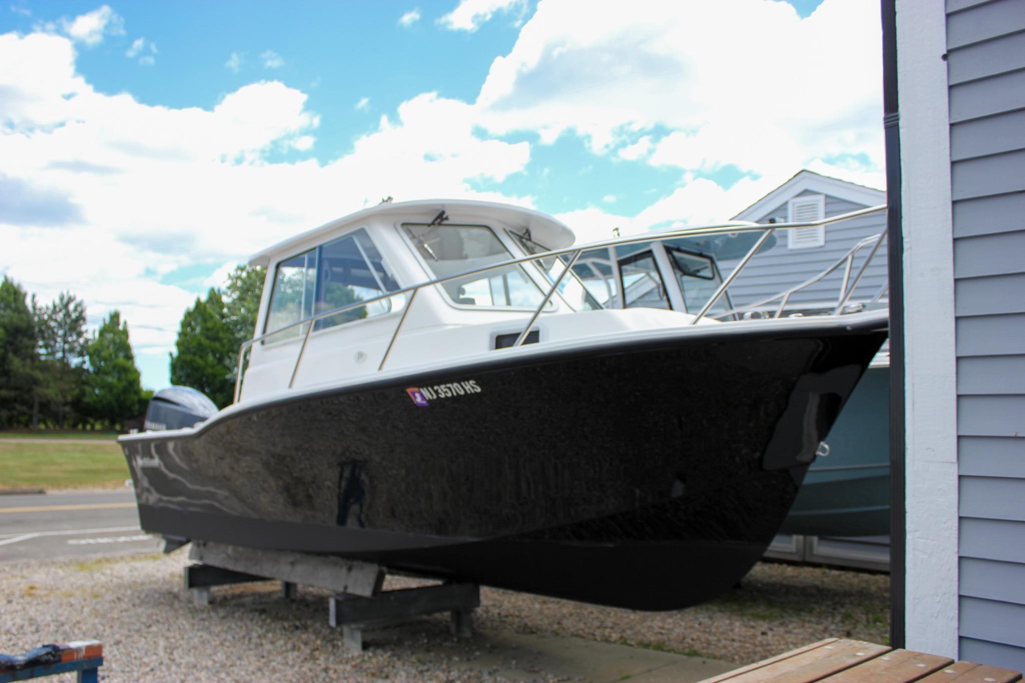 2022 NorthCoast 235 Cabin boat on display, parked outdoors under a blue sky.