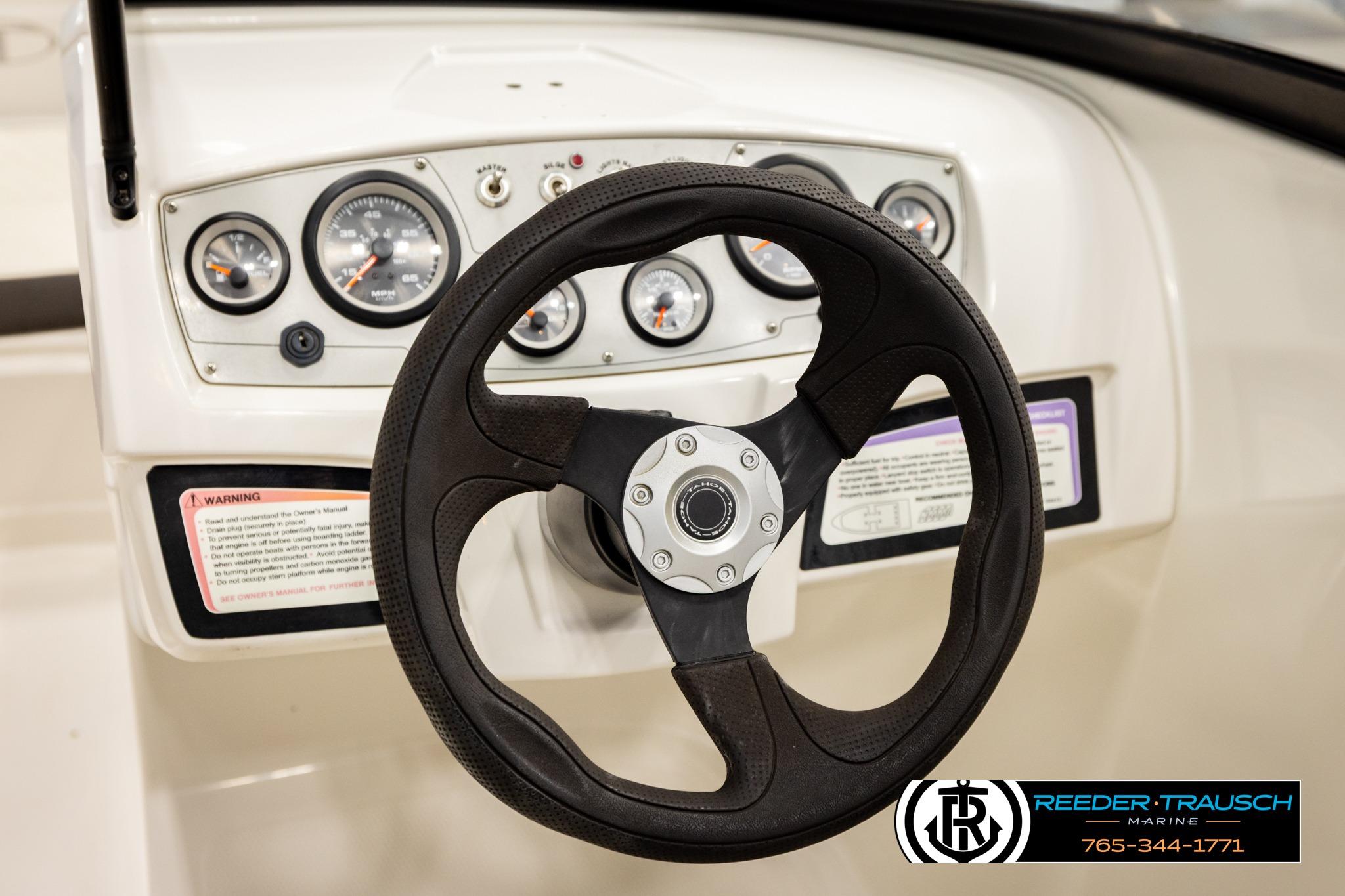 Steering wheel and dashboard of 2016 Tahoe 450 TS boat, featuring gauges and controls.