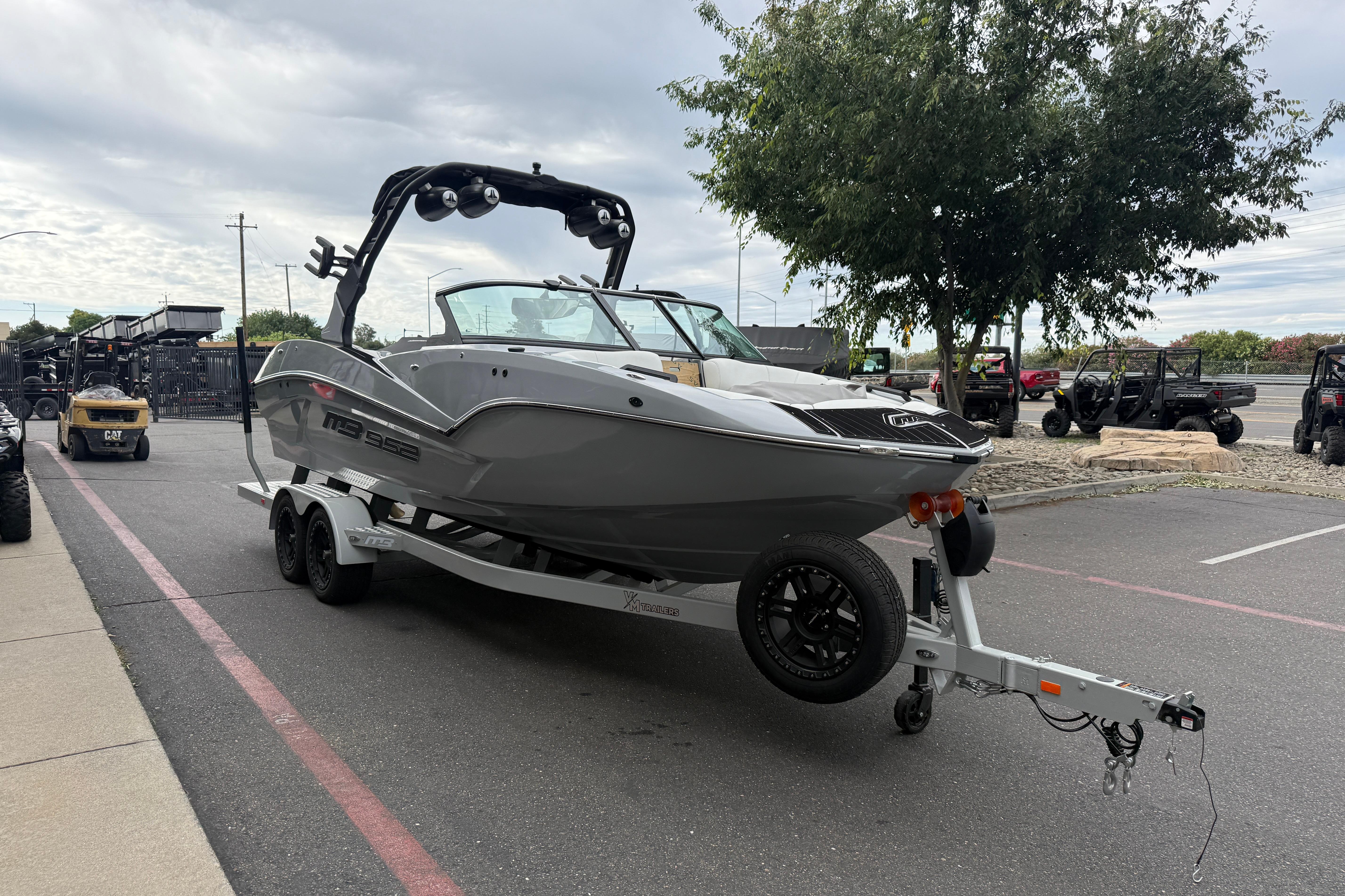2026 MB B52 23 Alpha boat on trailer in parking lot, overcast sky.