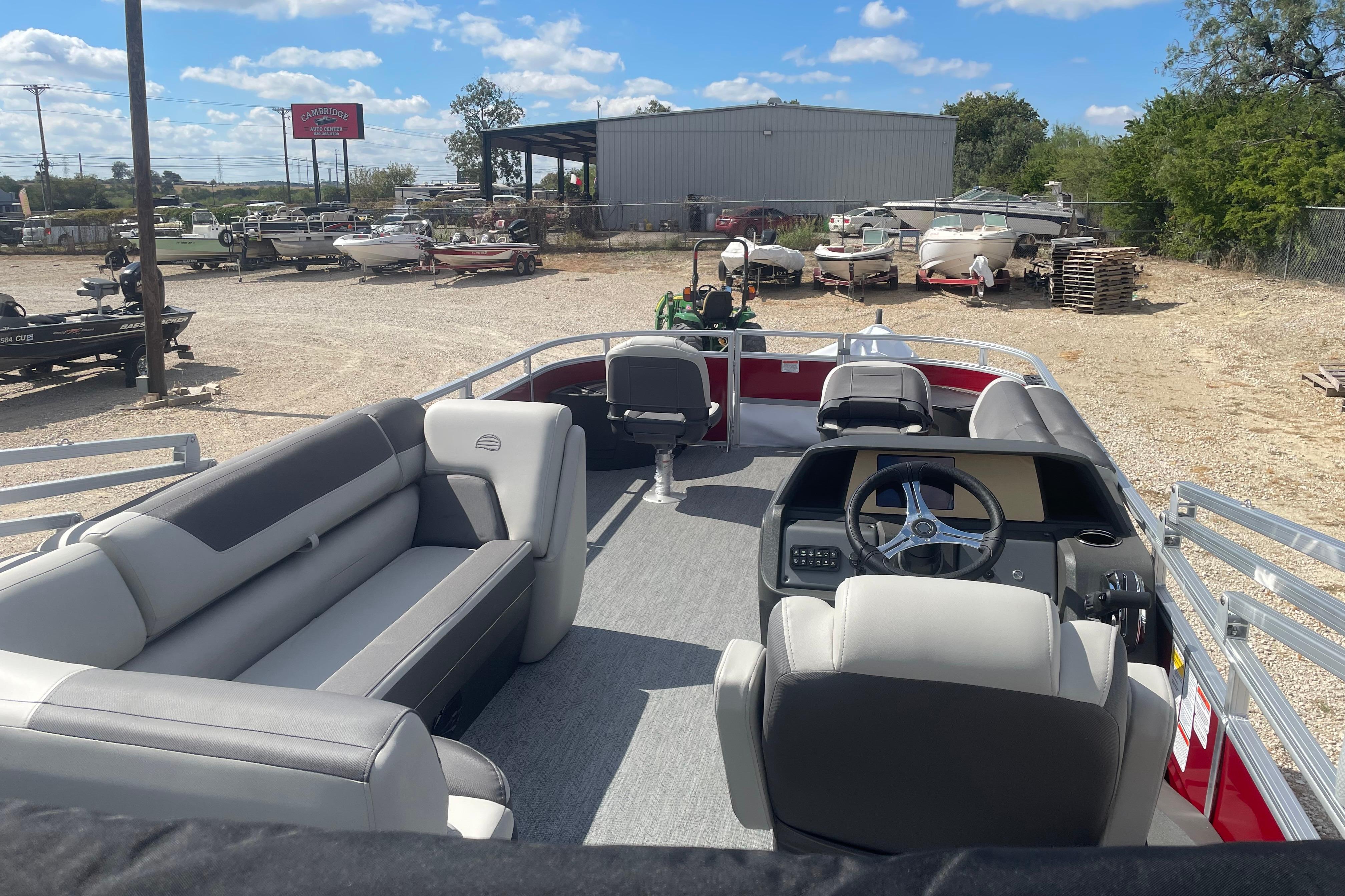 2026 Sun Tracker Fishin' Barge 22 DLX pontoon boat with spacious seating and steering console.