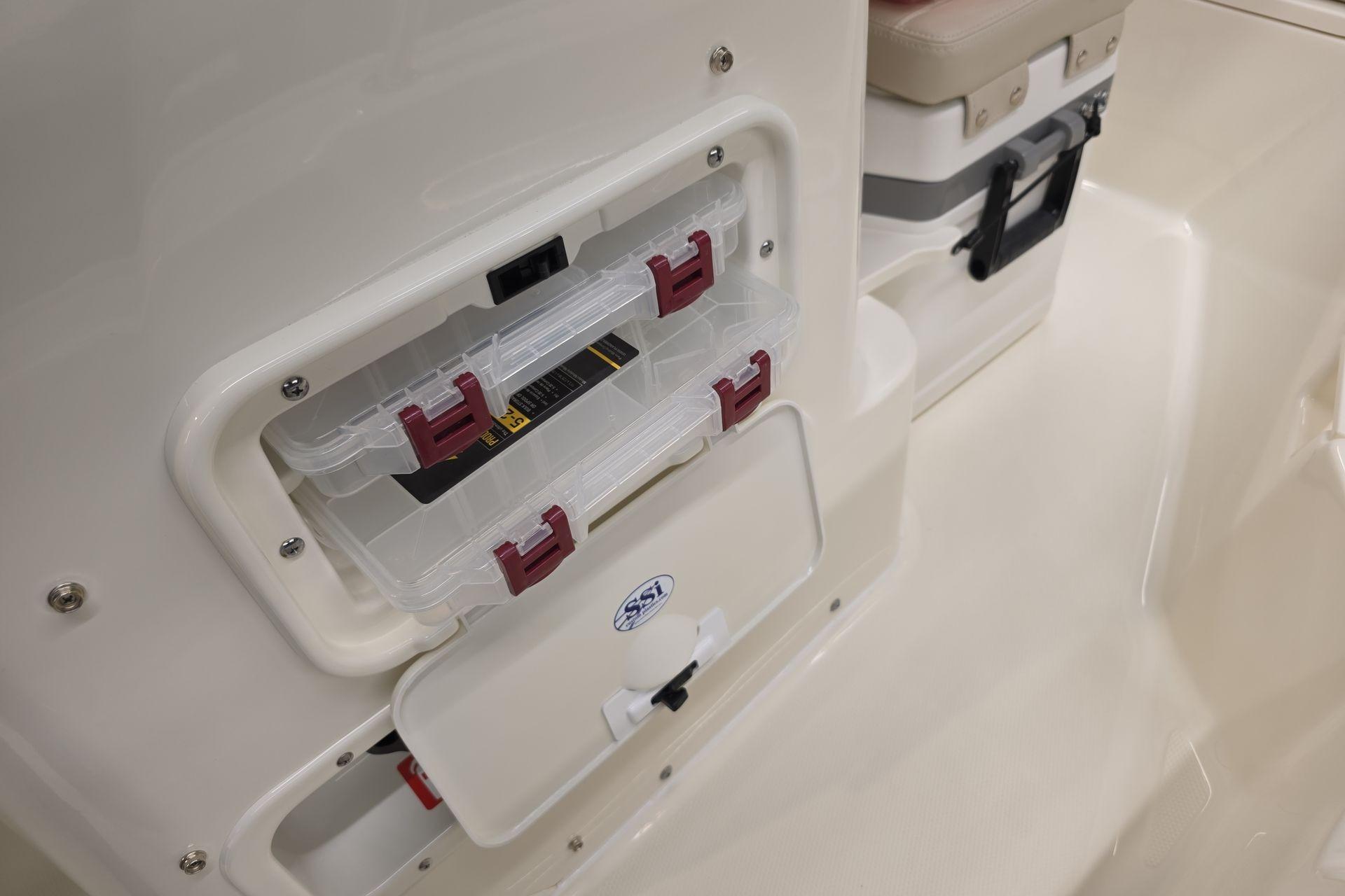 2026 Boston Whaler 150 Montauk storage compartment with tackle boxes and cooler.