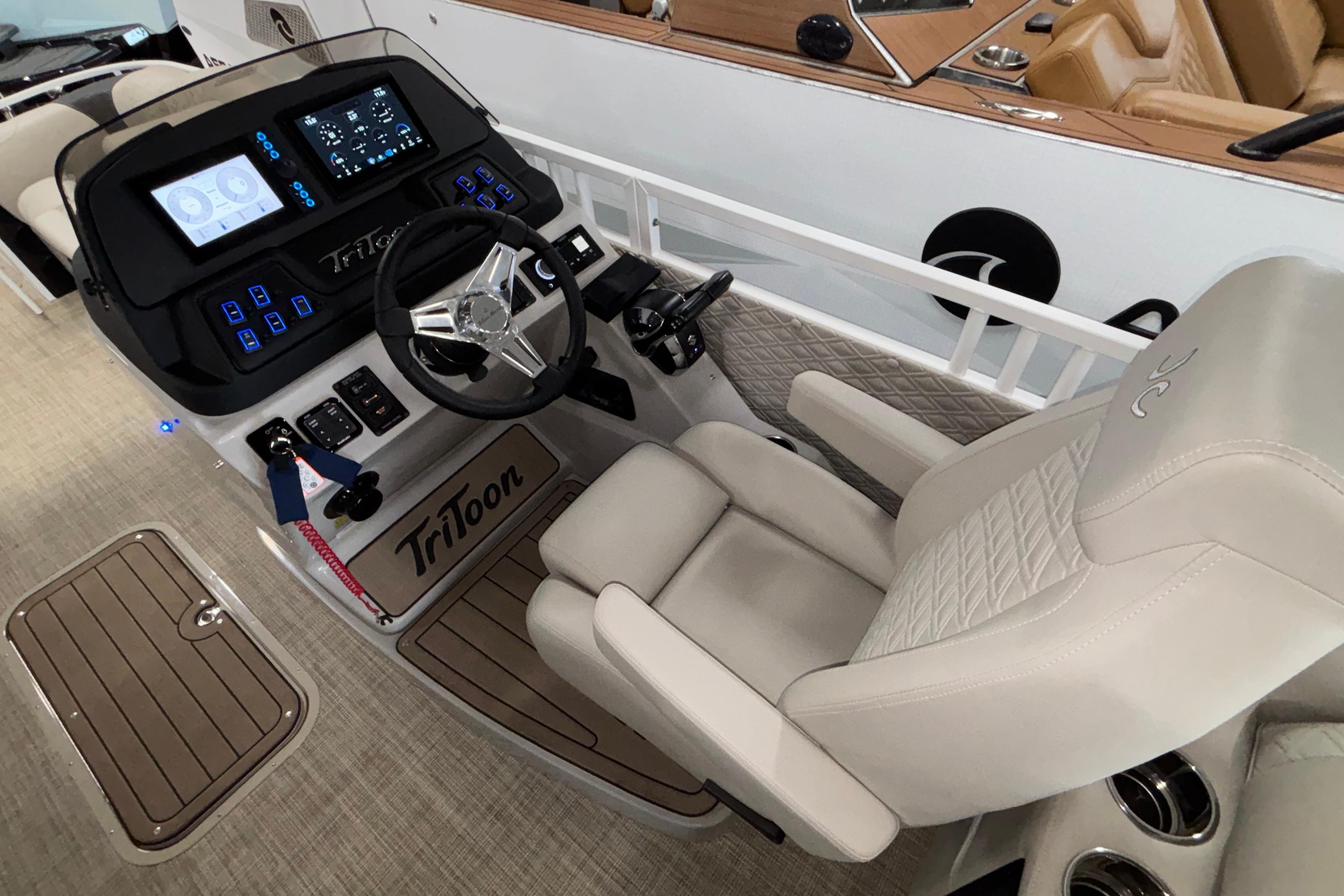 Luxurious helm of 2026 JC Sporttoon 26TT boat with advanced controls and plush seating.