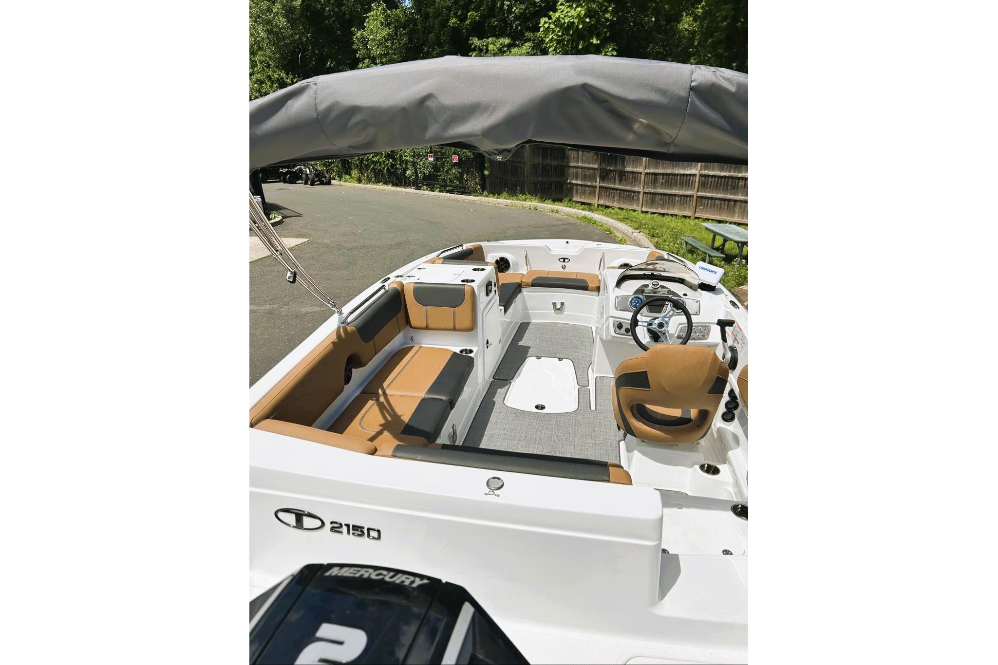 2026 Tahoe 2150 boat interior with seating and steering wheel, parked outdoors.