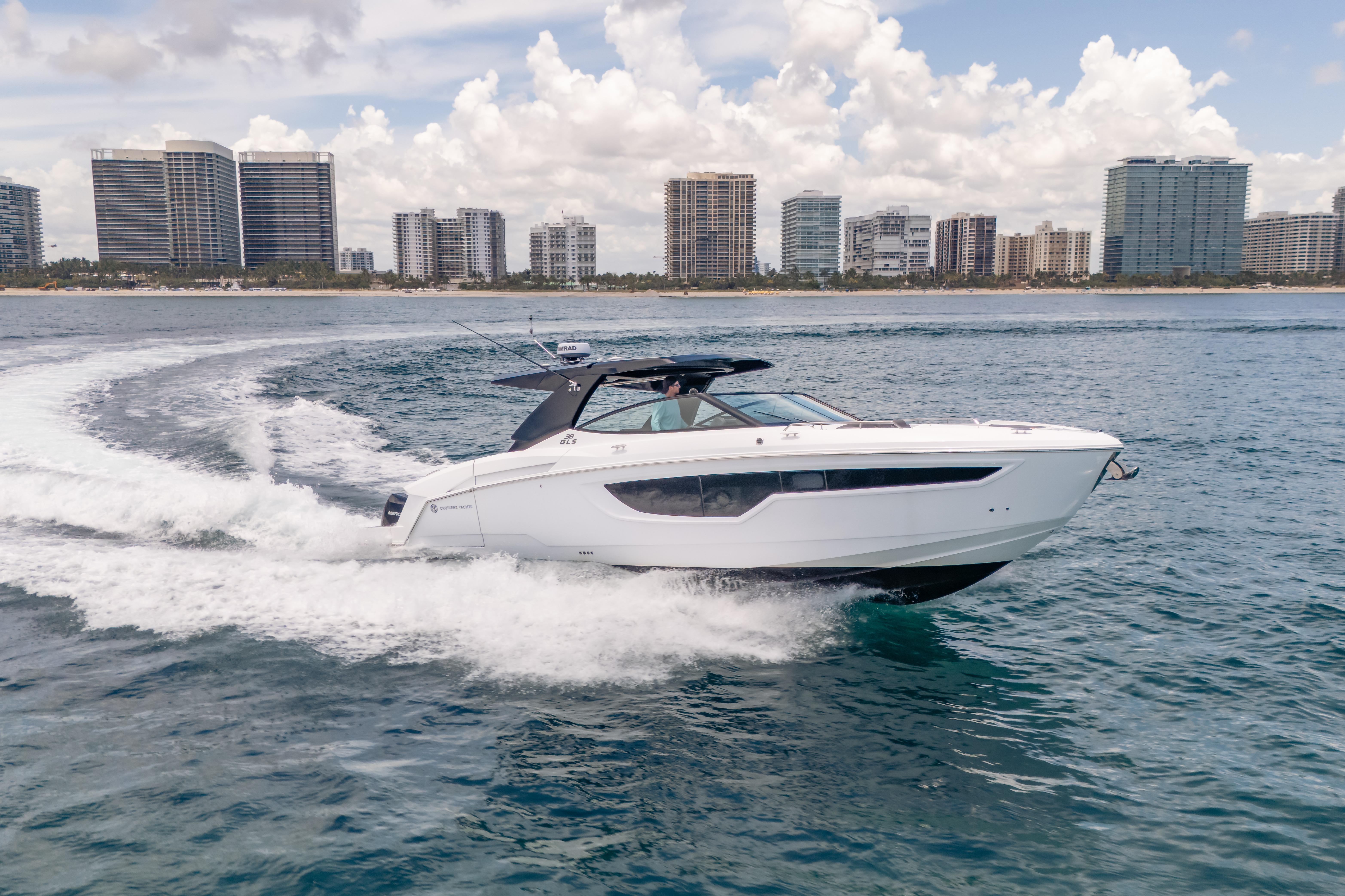 2021 Cruisers Yachts 38 GLS cruising near city skyline on a sunny day.