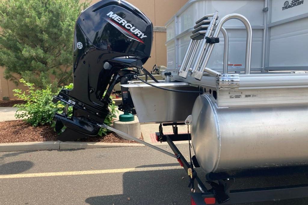 2026 Sun Tracker Party Barge 18 DLX with Mercury outboard motor, parked outdoors.
