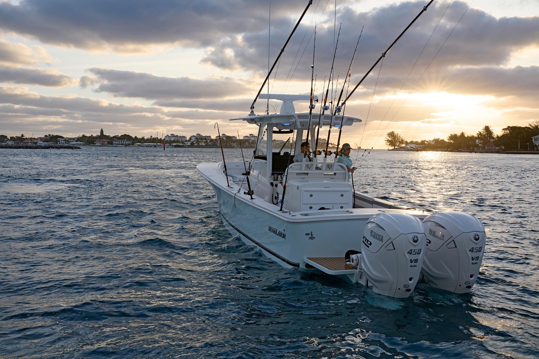 2025 Regulator 31 boat cruising at sunset with fishing rods and twin Yamaha engines.