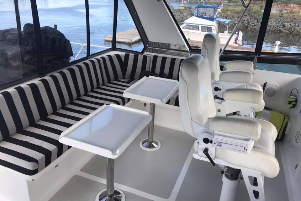 Interior of 1999 Grand Alaskan Pilothouse with striped seating and white captain chairs.