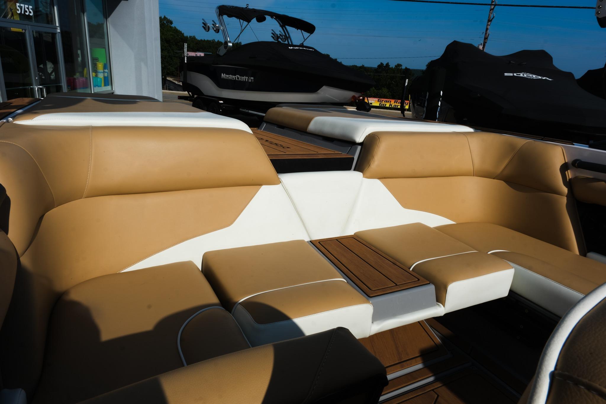 2023 Moomba Mondo boat interior with tan and white seating, wooden accents.