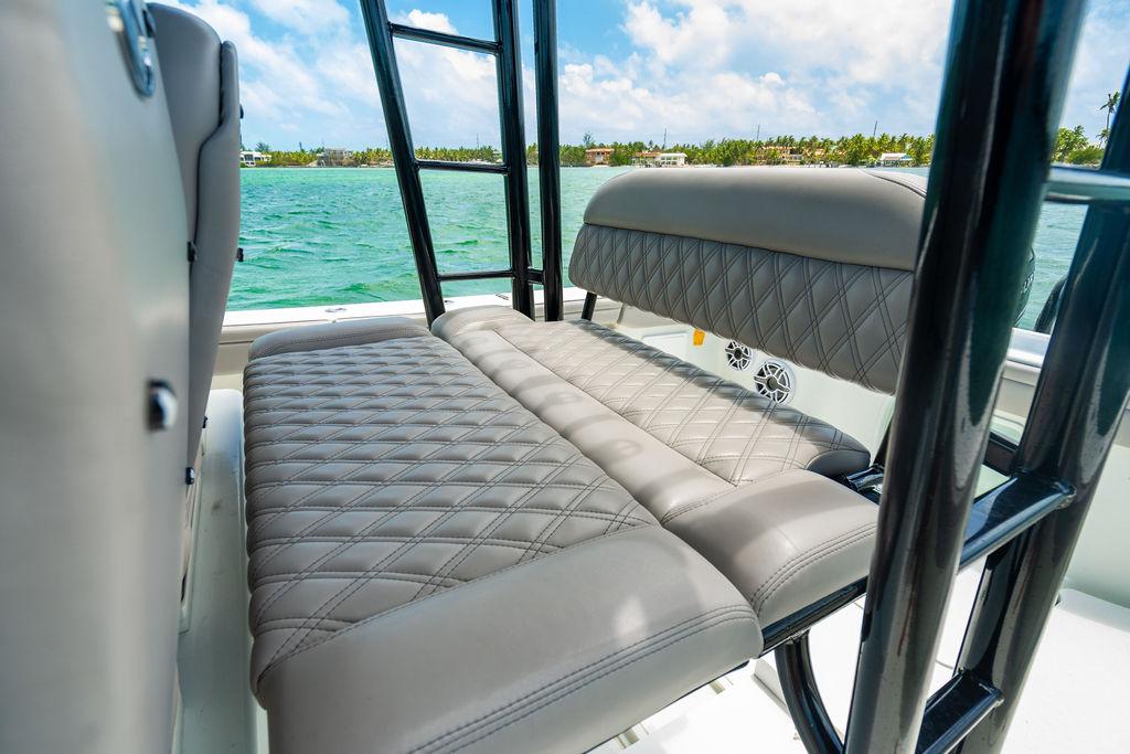 2015 Yellowfin CC boat with cushioned seating, black frame, and ocean view.