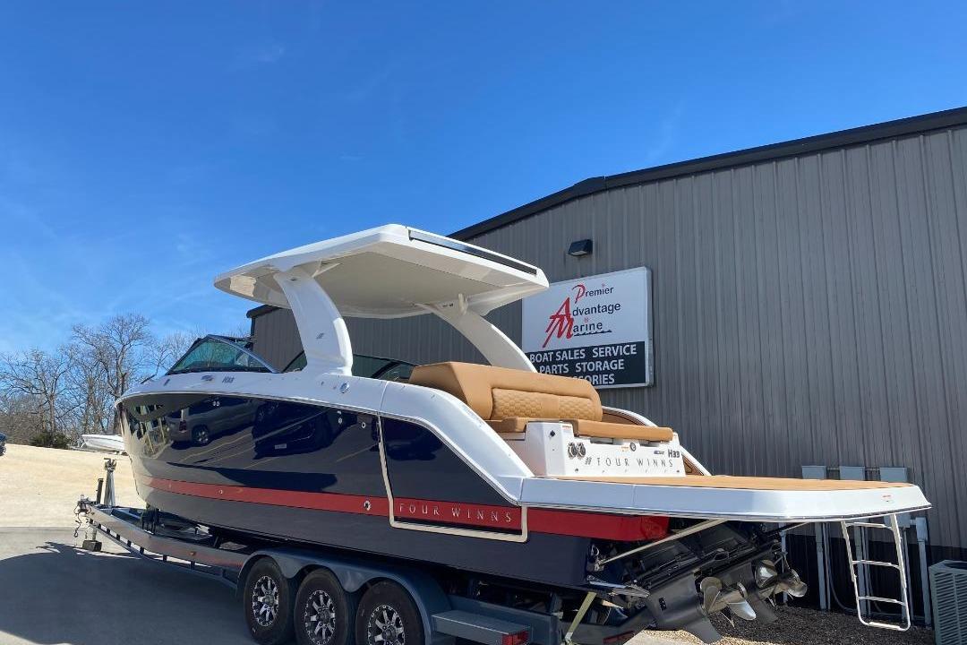 2026 Four Winns H33 boat on trailer at marine dealership.