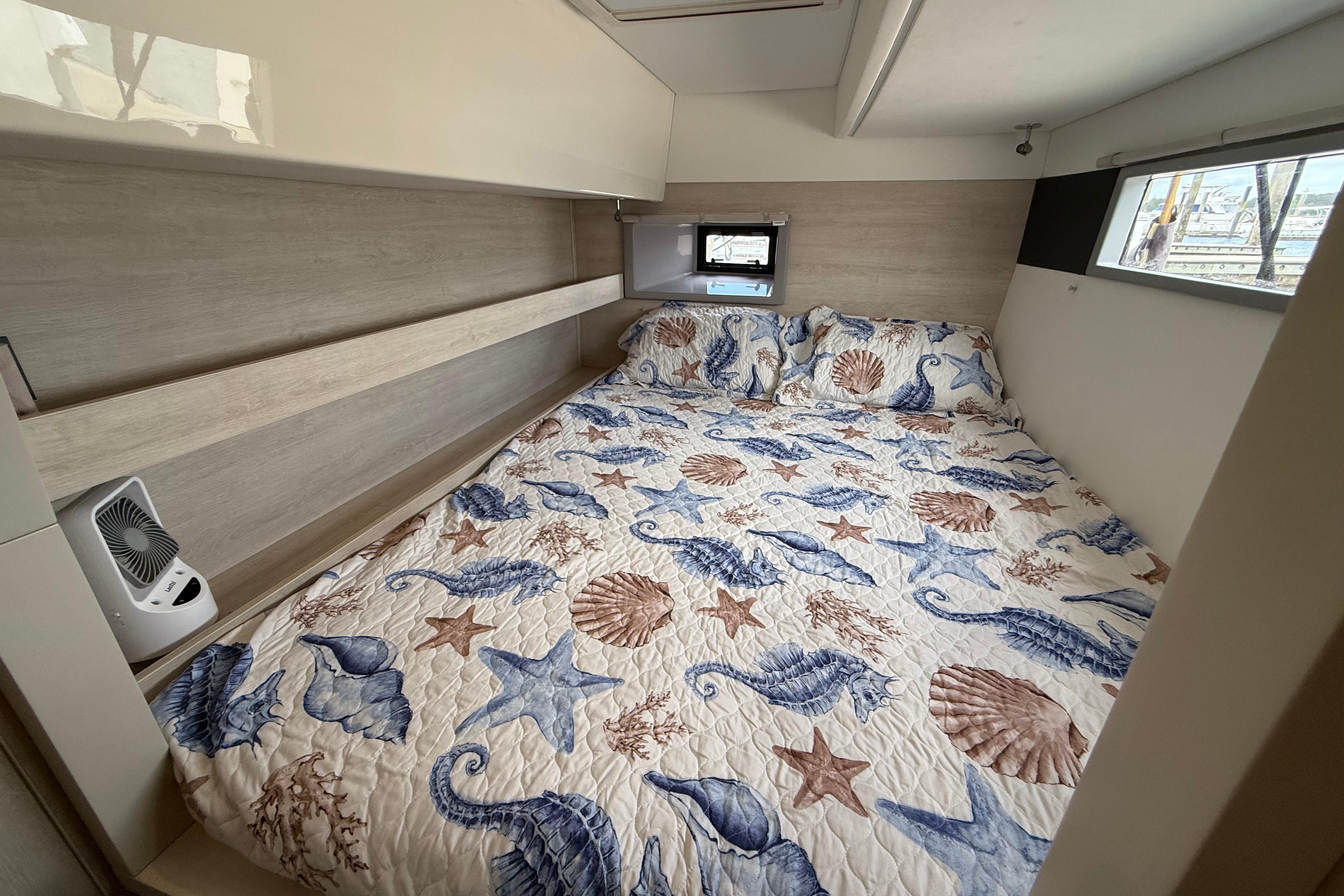 Cozy bedroom in 2021 Leopard 43 Powercat with nautical-themed bedding and modern decor.