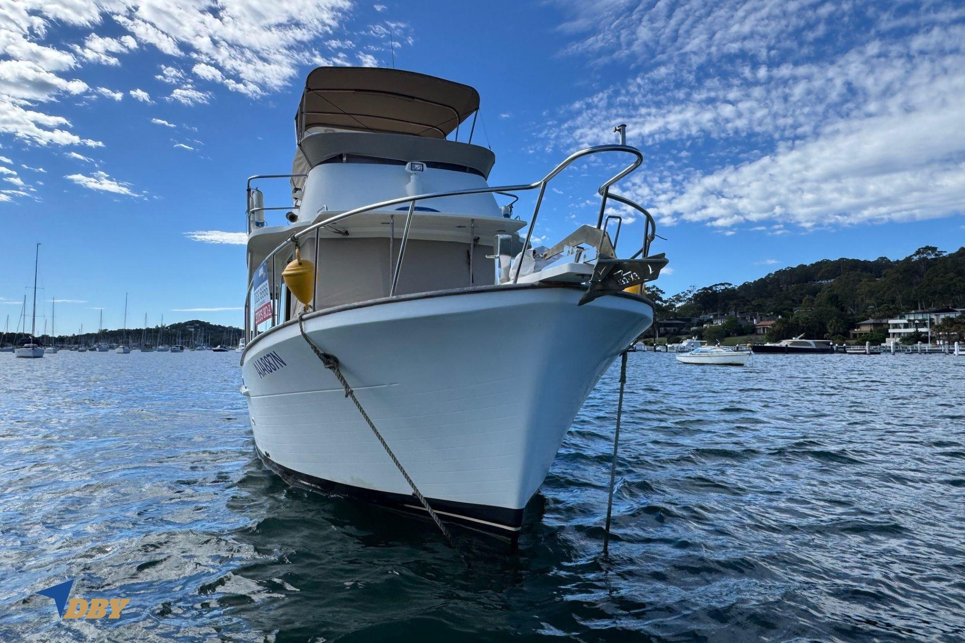 2006 Clipper 34 boat anchored in a scenic harbor with clear skies.