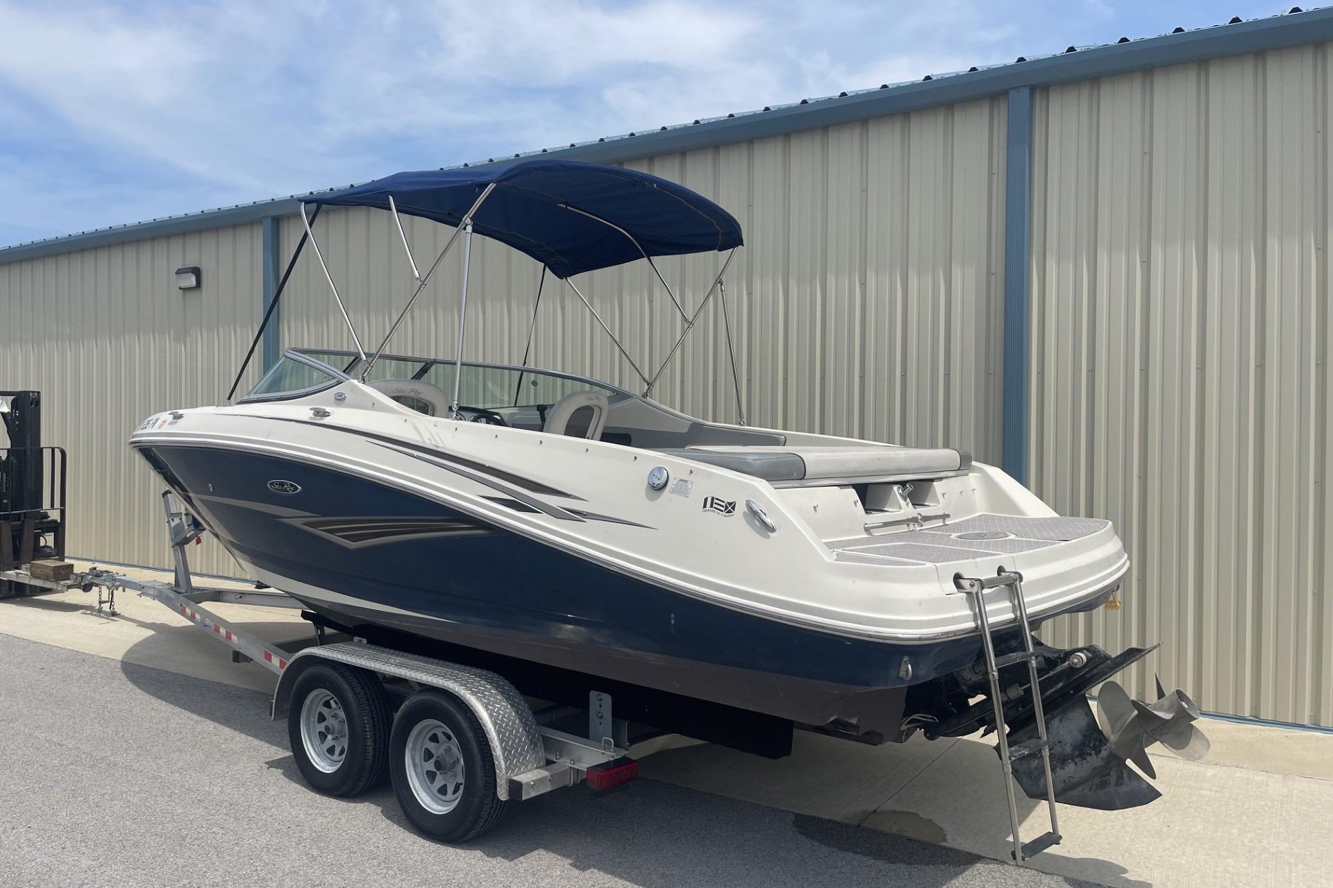 2010 Sea Ray 230 Bow Rider Select boat on trailer, parked near a metal building.