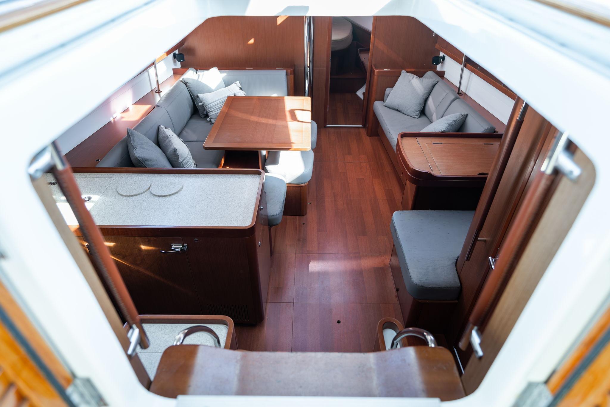 Interior of 2013 Beneteau Oceanis 50 yacht, featuring elegant wood finish and cozy seating.