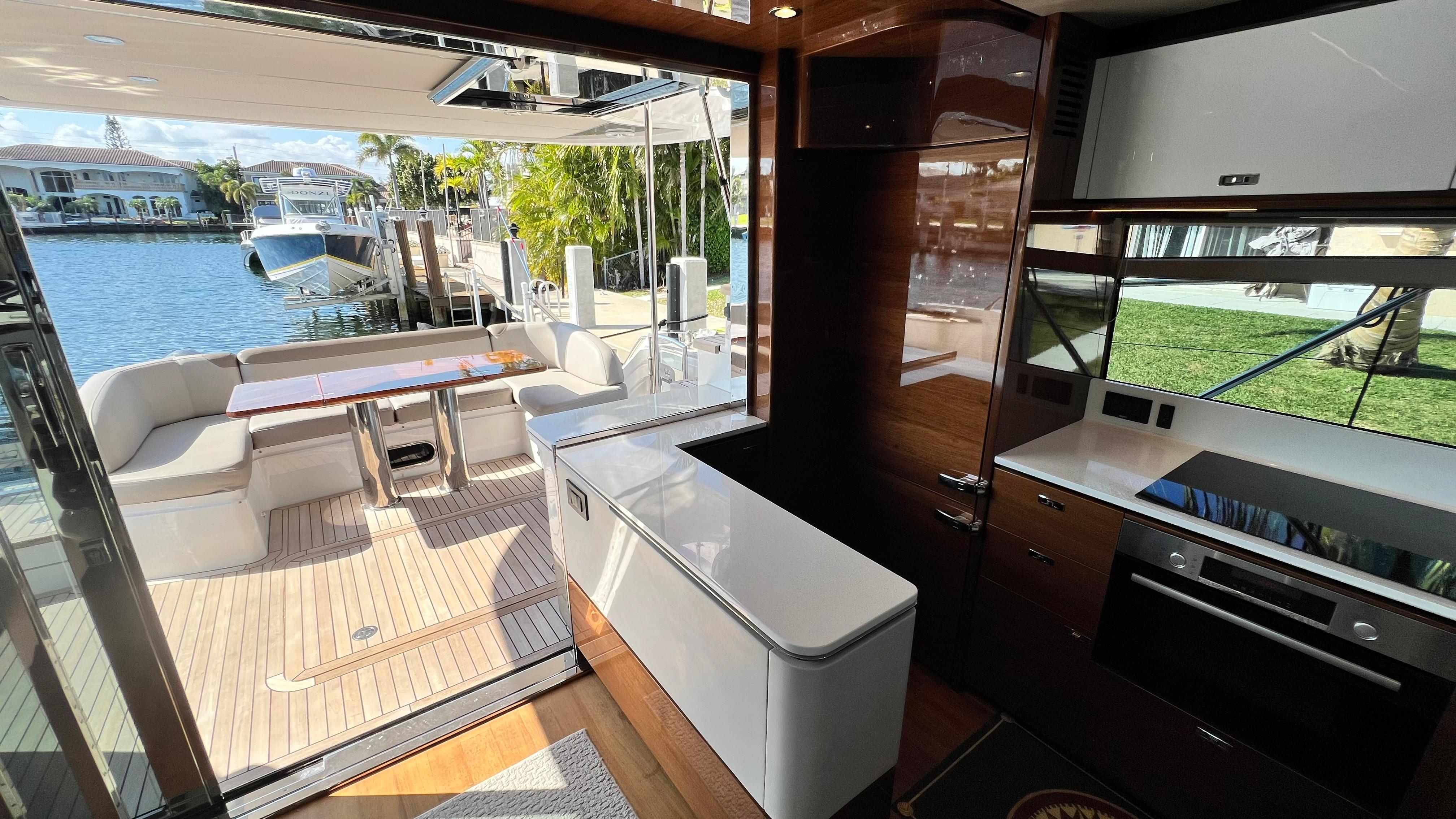 Luxurious 2019 Princess F62 yacht interior with modern kitchen and outdoor seating area.