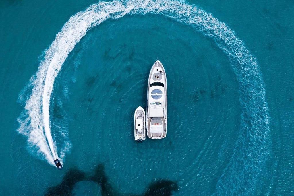Aerial view of 2006 Sunseeker Predator 82 yacht with jet ski in turquoise water.