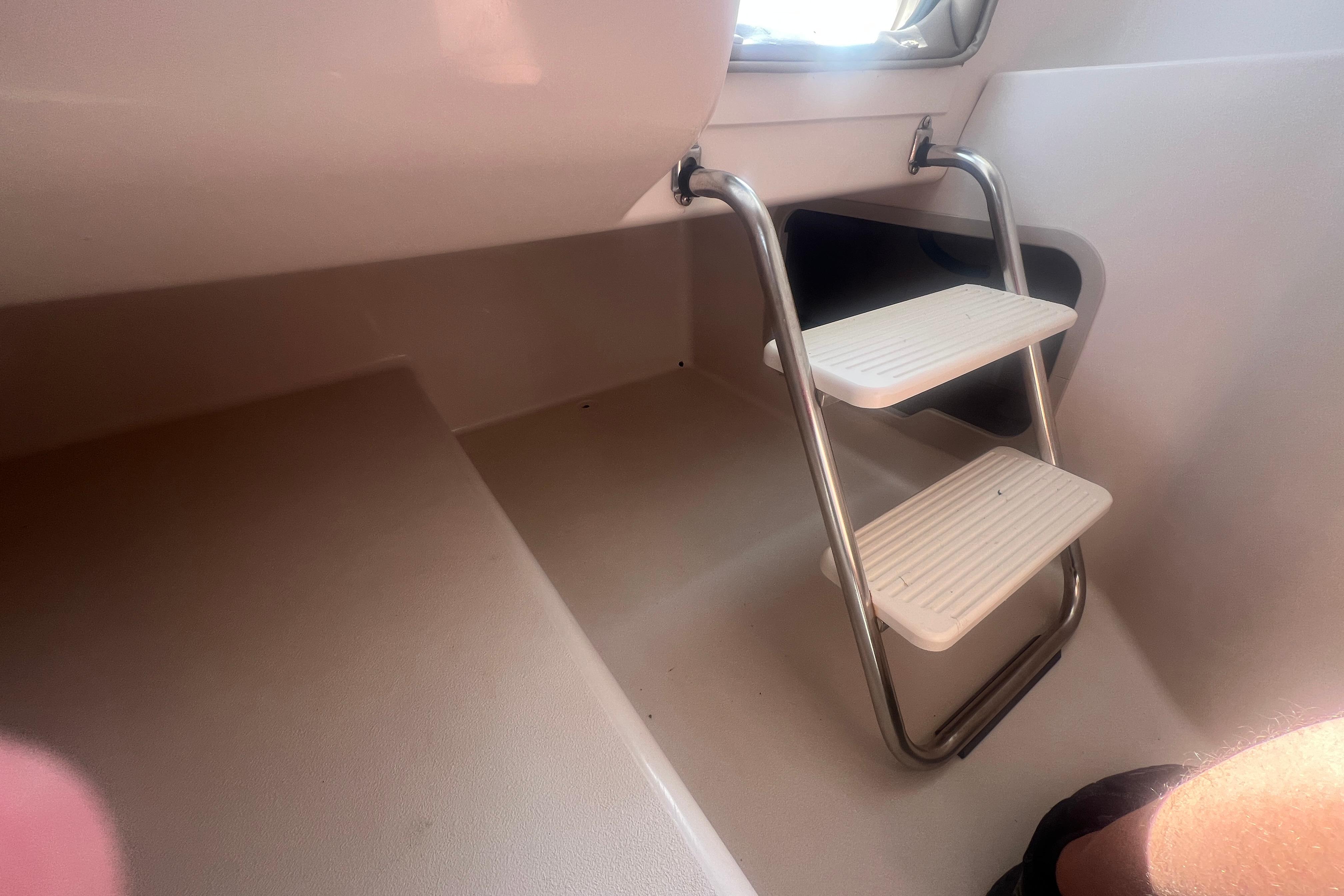 Interior view of 2002 Hurricane SunDeck 260 OB boat with metal ladder steps.
