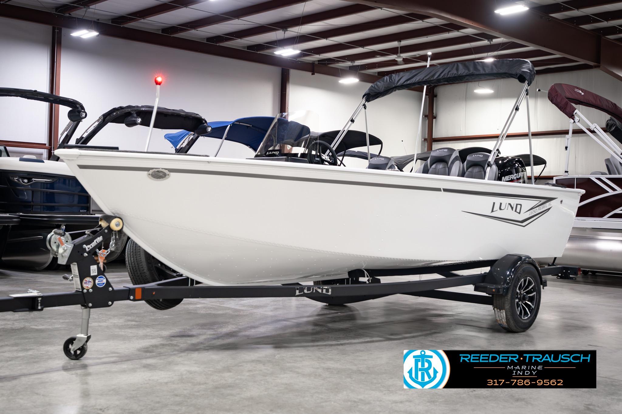 2026 Lund 1650 Rebel XL SS boat on trailer in showroom setting.