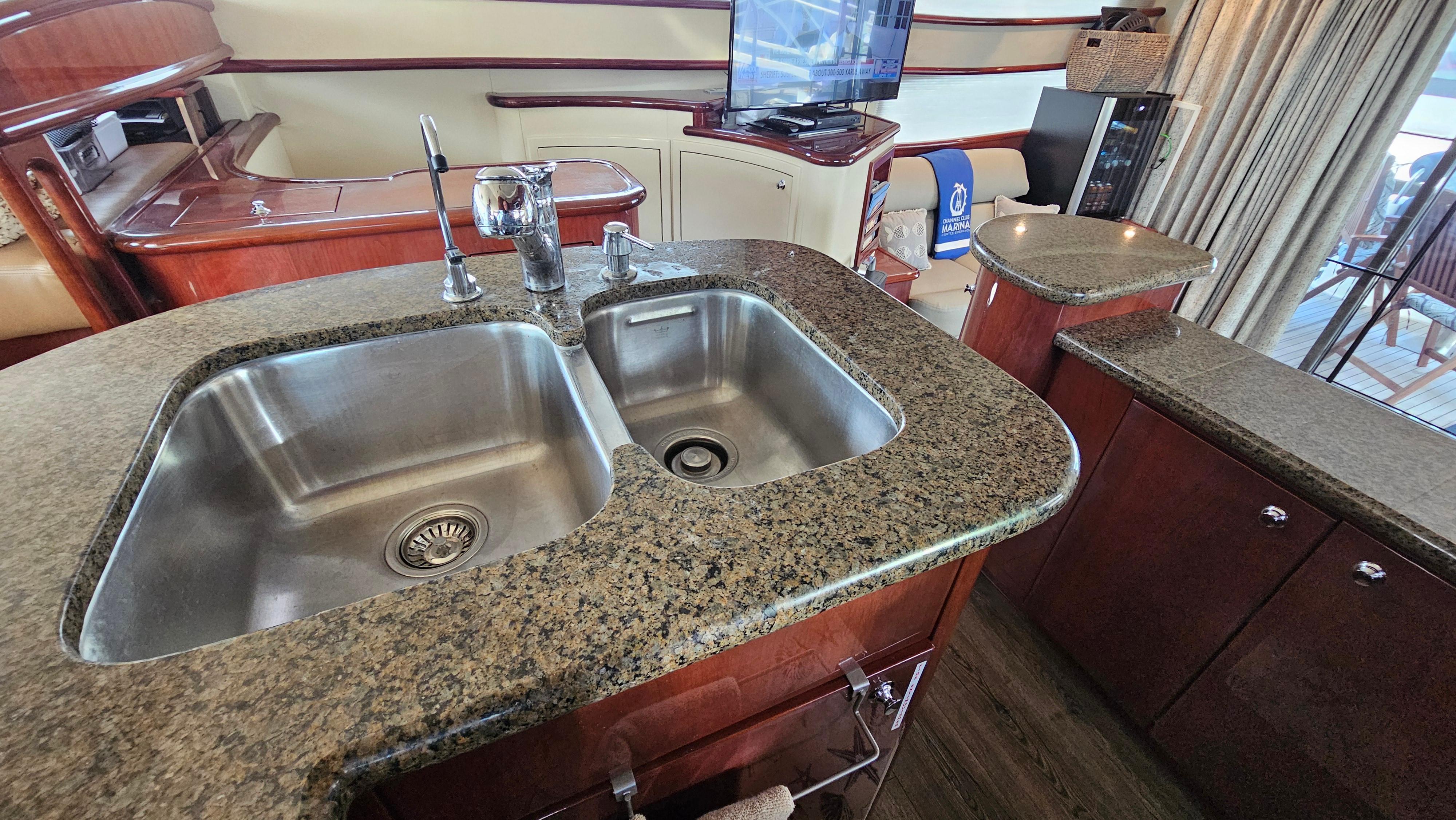 Luxurious kitchen area in 2005 Neptunus 56 Flybridge yacht with granite countertops.