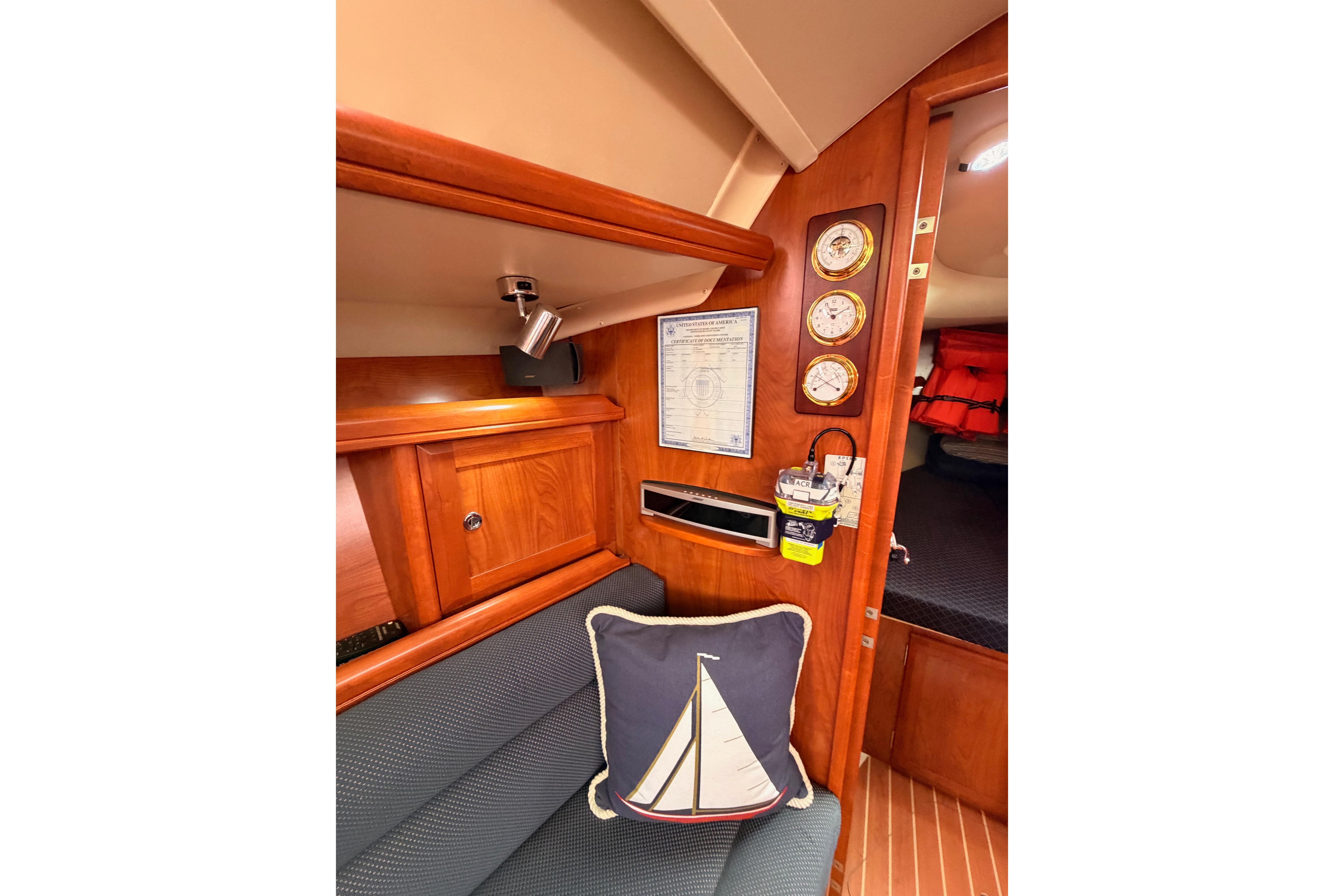 Interior of 2009 Hunter 38 sailboat with nautical decor and wooden cabinetry.