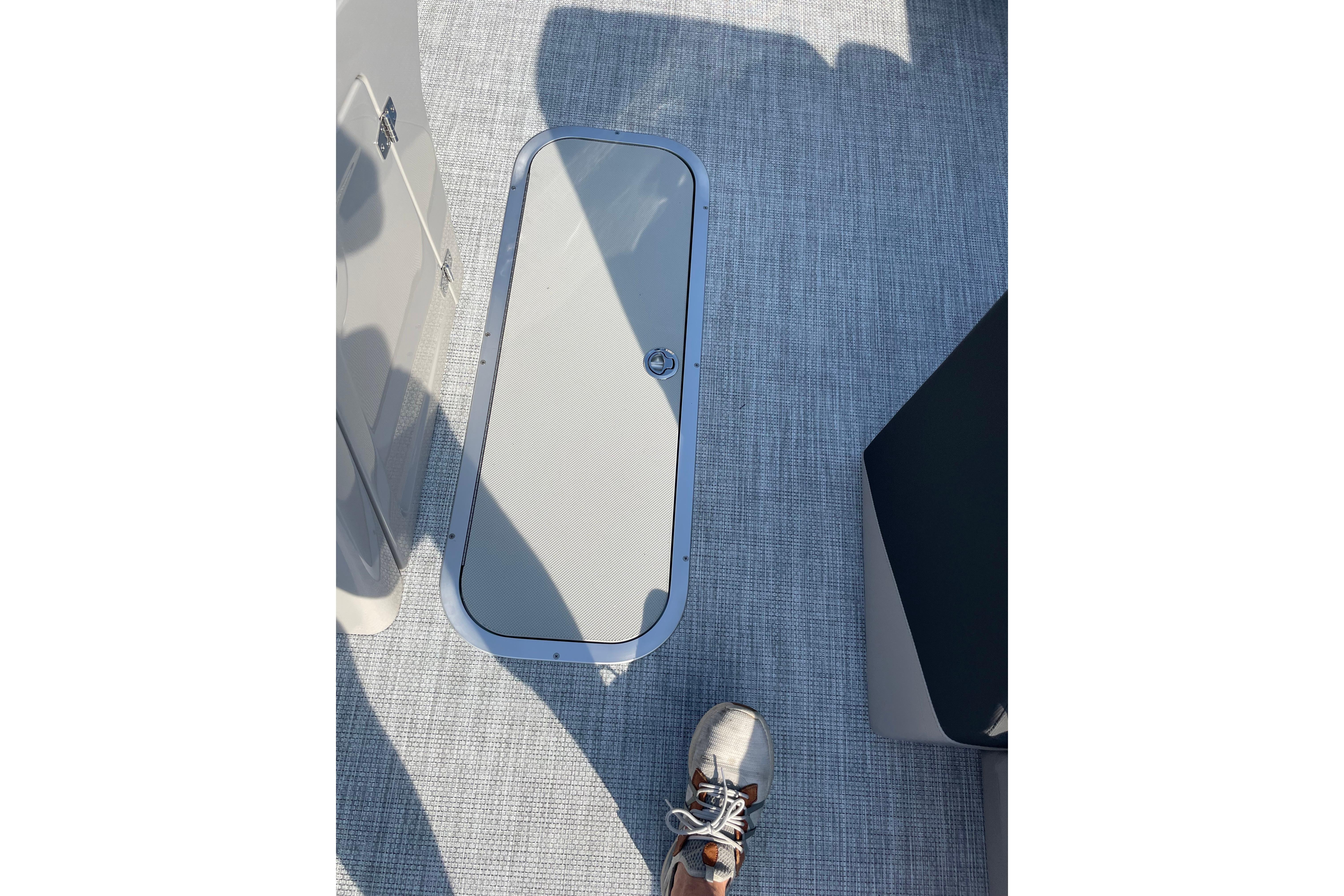 Floor hatch on Alera a24 boat, 2027 model, with textured surface and shoe visible.