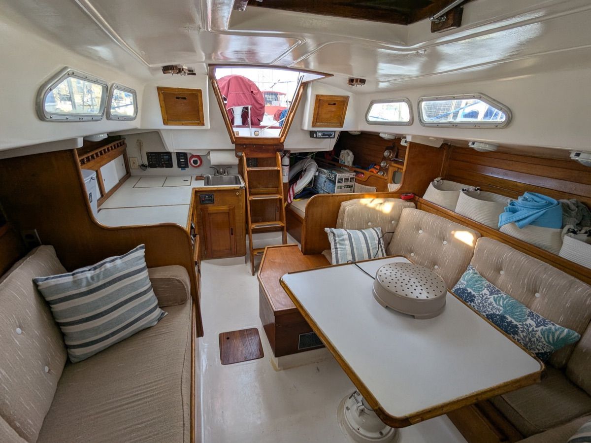 Interior of a 1984 Ericson 35 sailboat with cozy seating and a table.