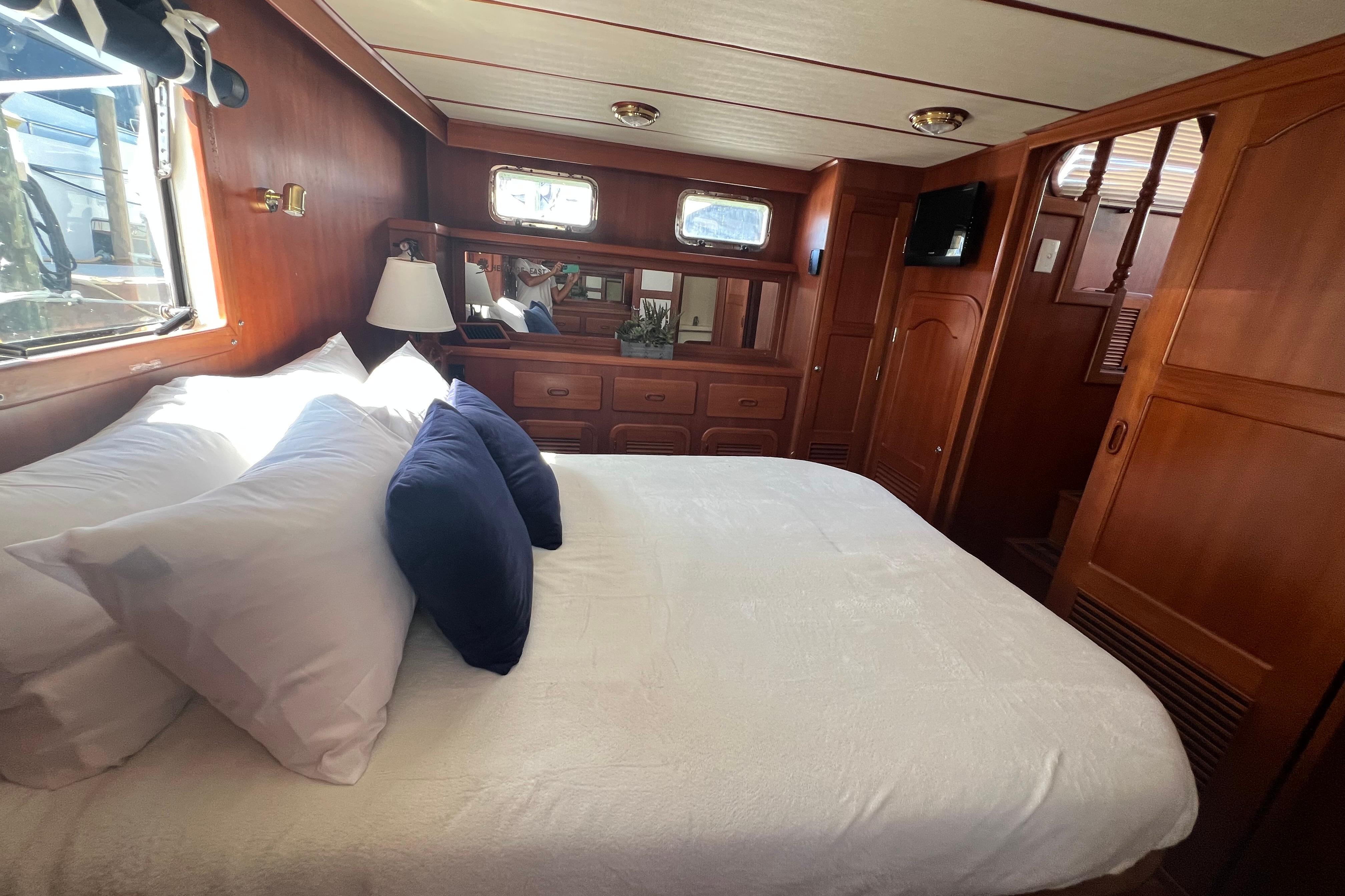 Luxurious bedroom interior of 2007 Heritage East 36 Sundeck Trawler with wood paneling.