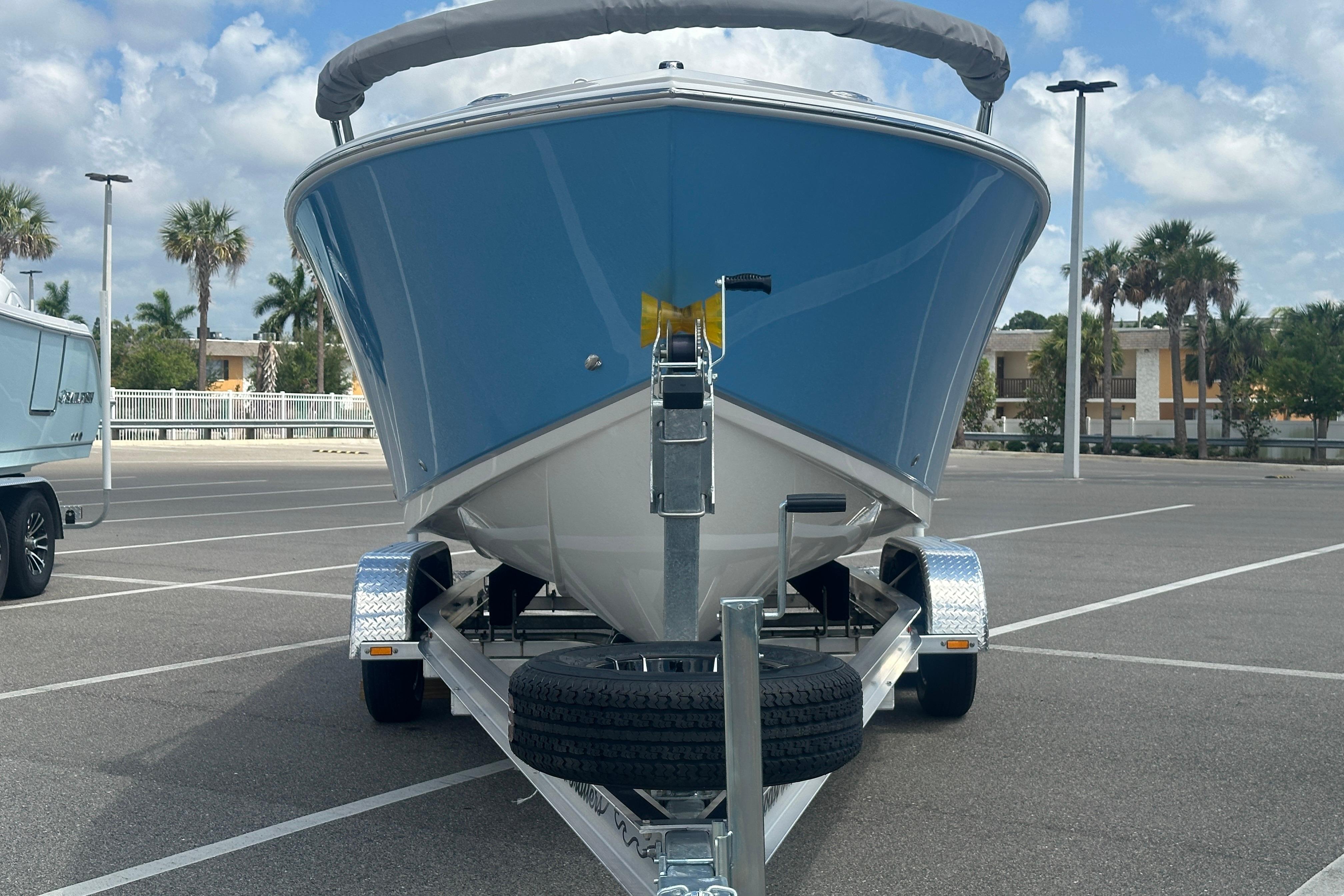 2026 Sailfish 226 DC boat on trailer in parking lot, palm trees in background.