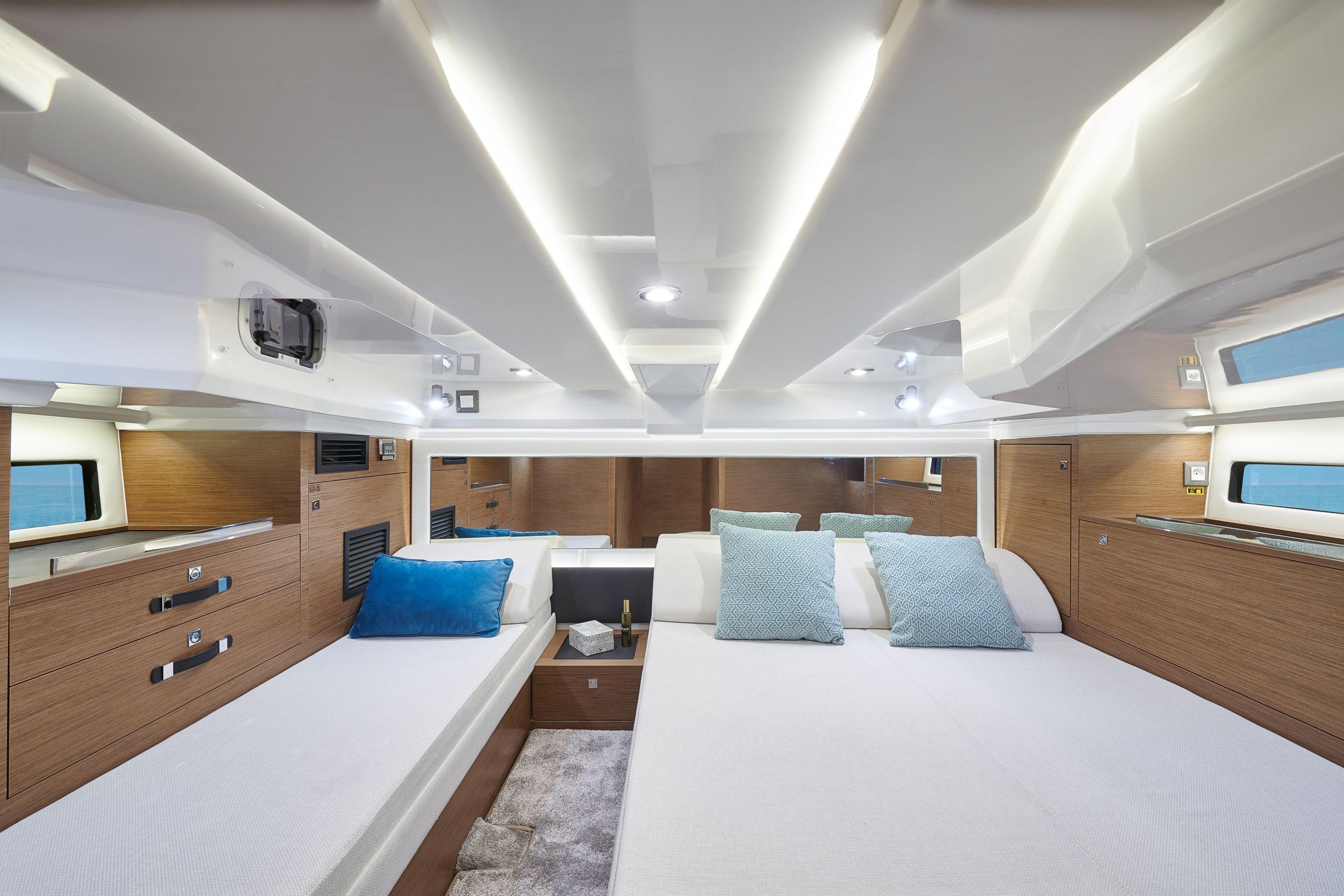 Luxurious interior of 2026 Jeanneau Leader 12.5 WA yacht with modern design and cozy bedding.