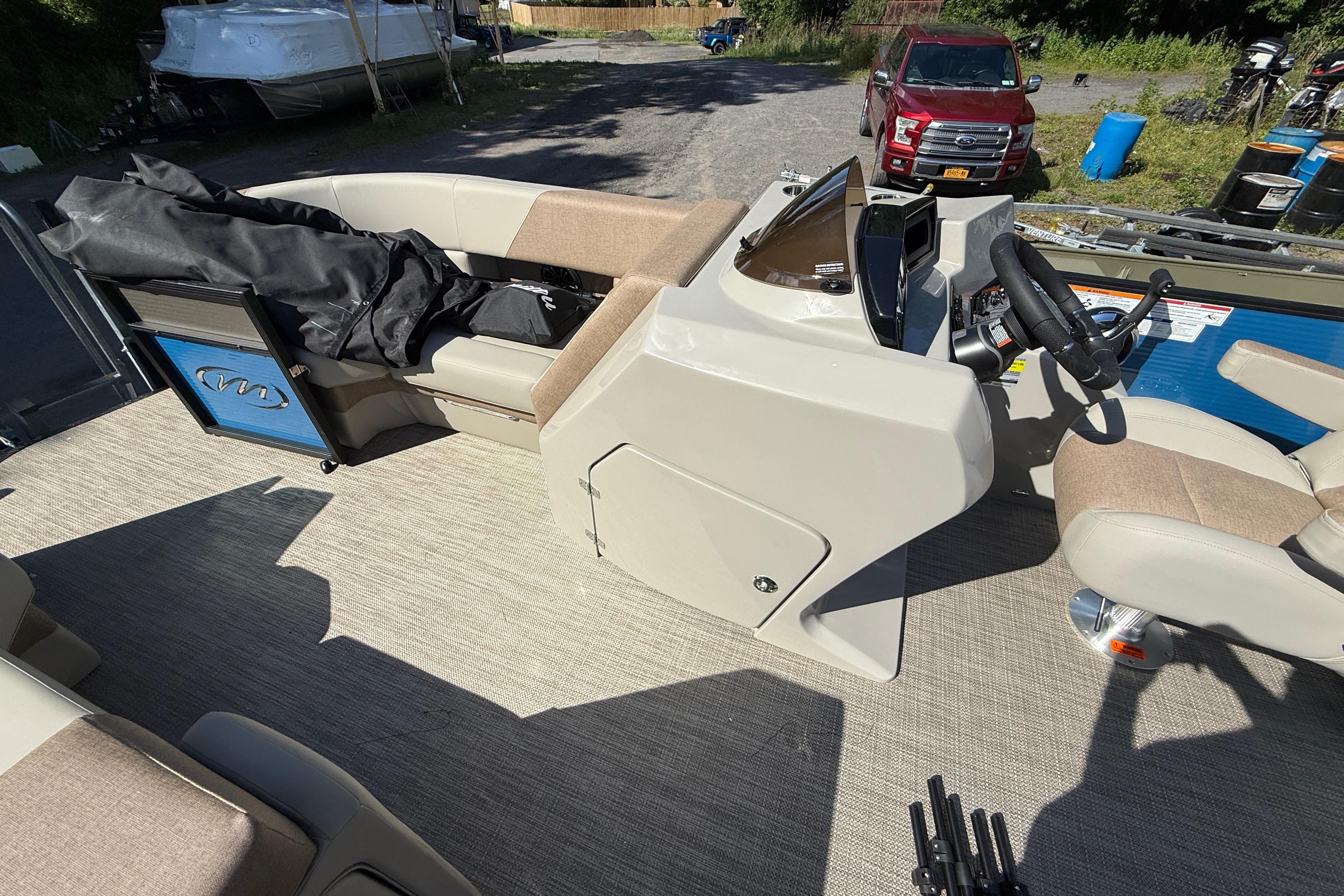 2027 Manitou Aurora RF 23 boat interior with steering console and seating.