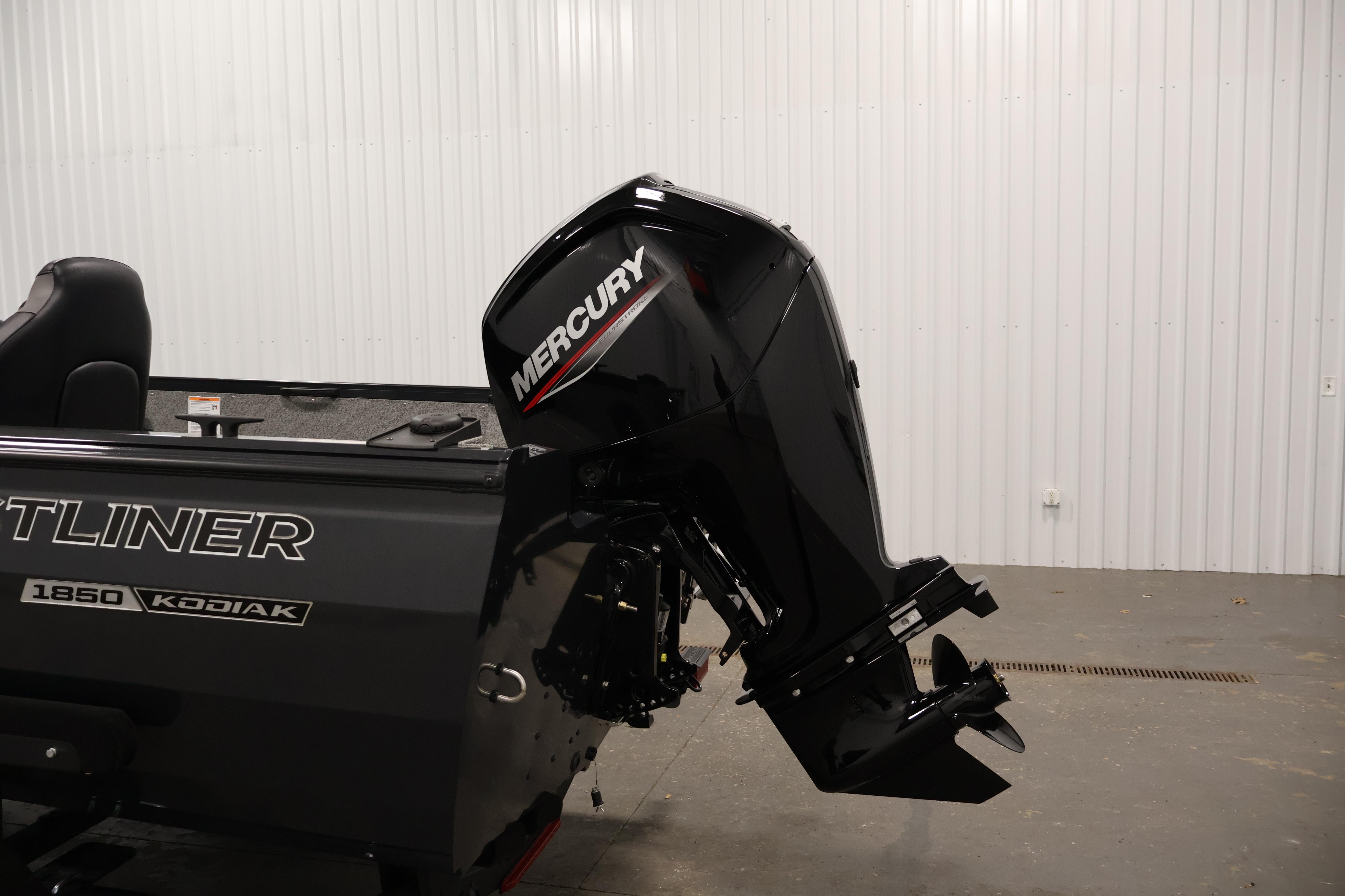 2026 Crestliner 1850 Kodiak SC boat with Mercury outboard motor in a garage.