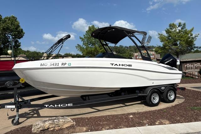 2024 Tahoe T21 boat on trailer, parked outdoors under clear sky.
