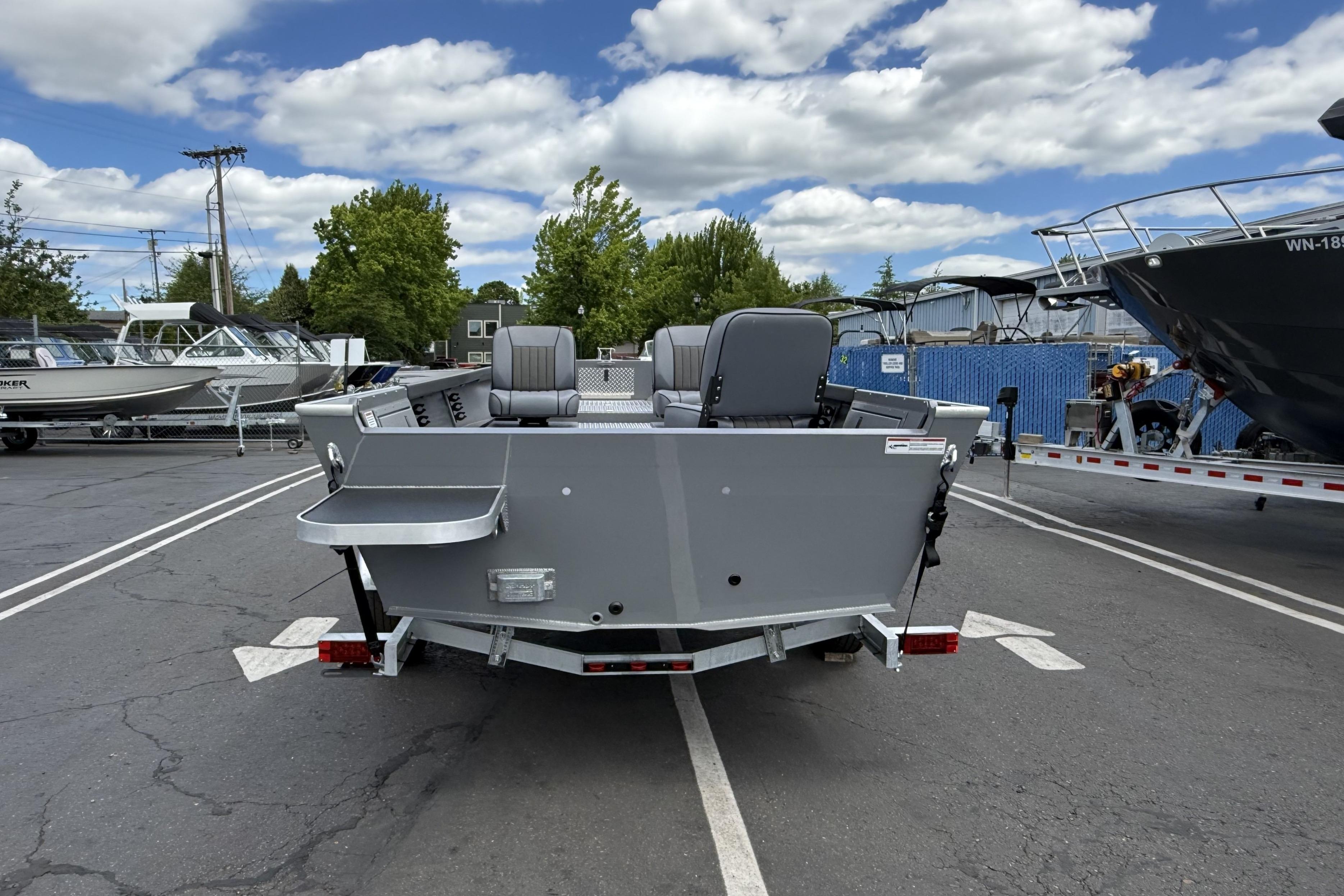 2026 Alumaweld Free Drifter 20 boat on trailer in parking lot, under cloudy sky.
