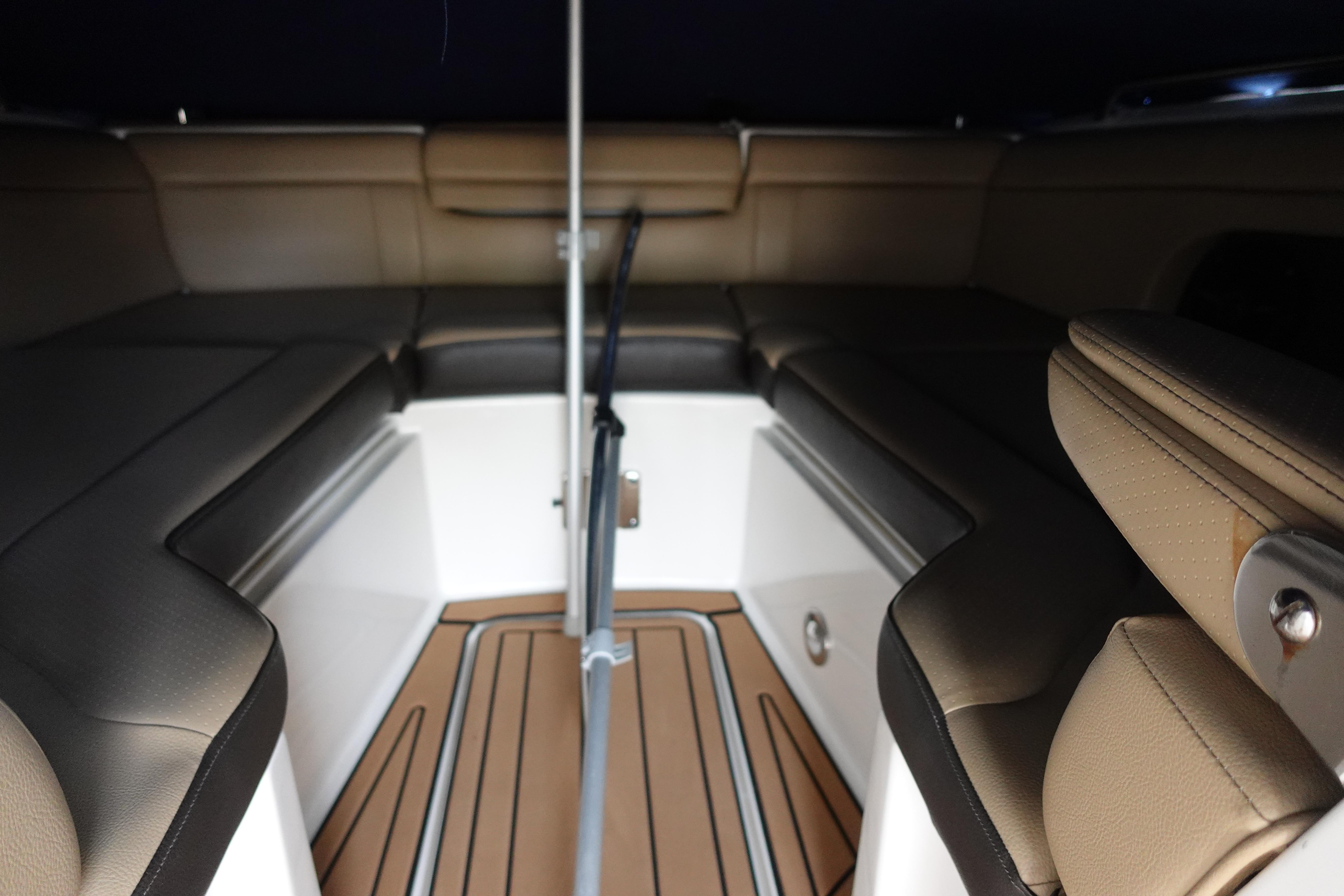 Interior view of 2018 Sea Ray SDX 270 boat with tan seating and wood flooring.