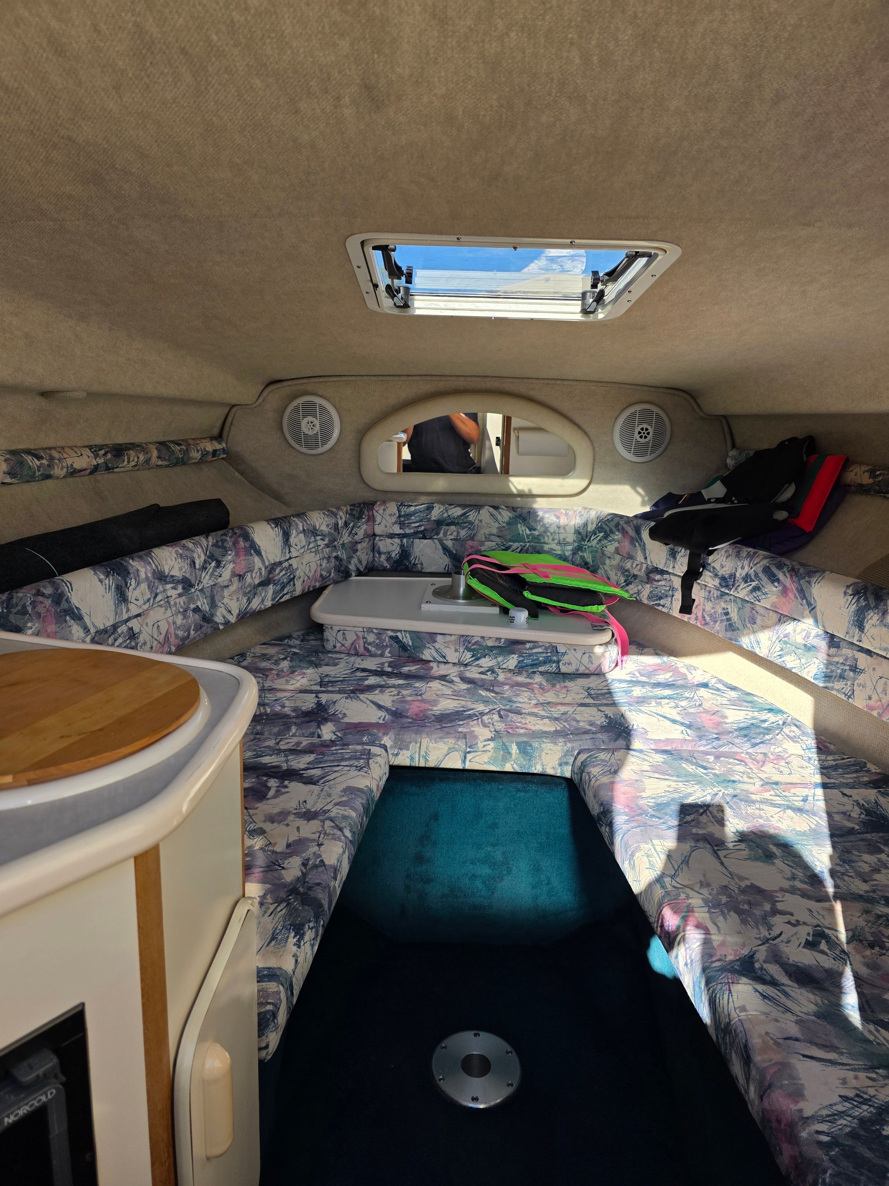 Interior of the 1997 Sea Ray 240 Sundeck with seating area and skylights.