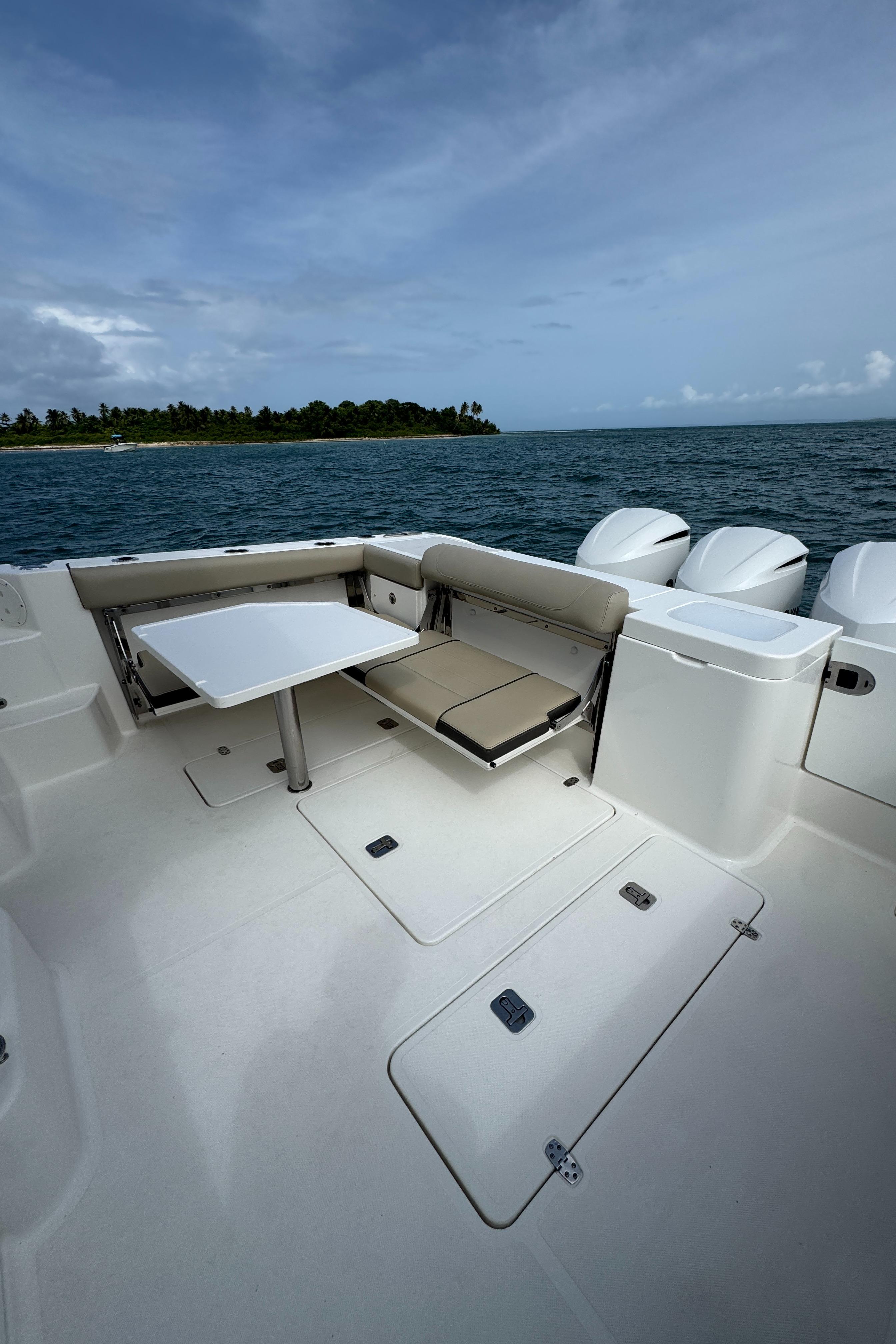2019 Pursuit OS 355 Offshore boat deck with seating, table, and ocean view.