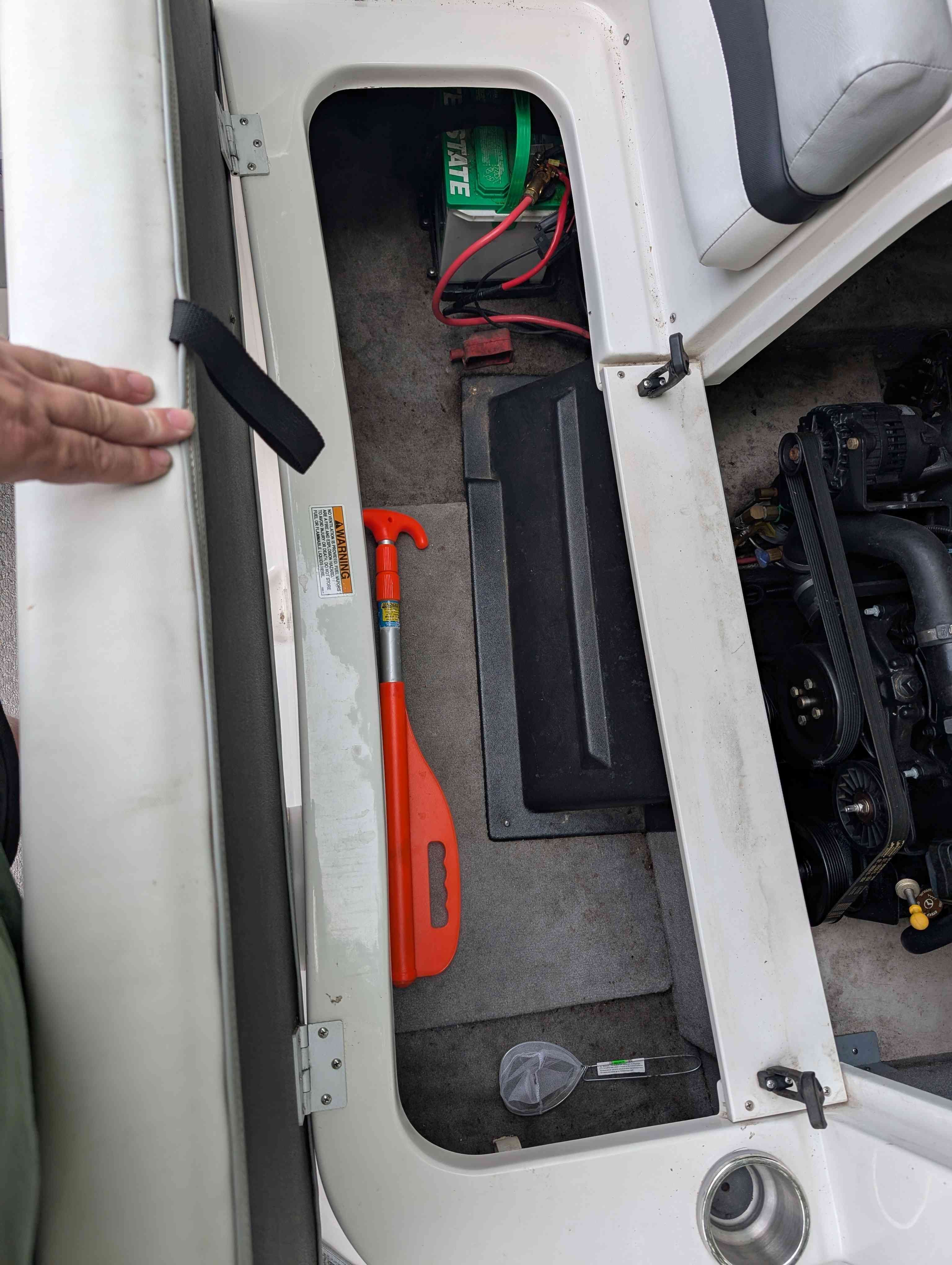 Starcraft 2000 boat engine compartment with battery and paddle, year 2015.