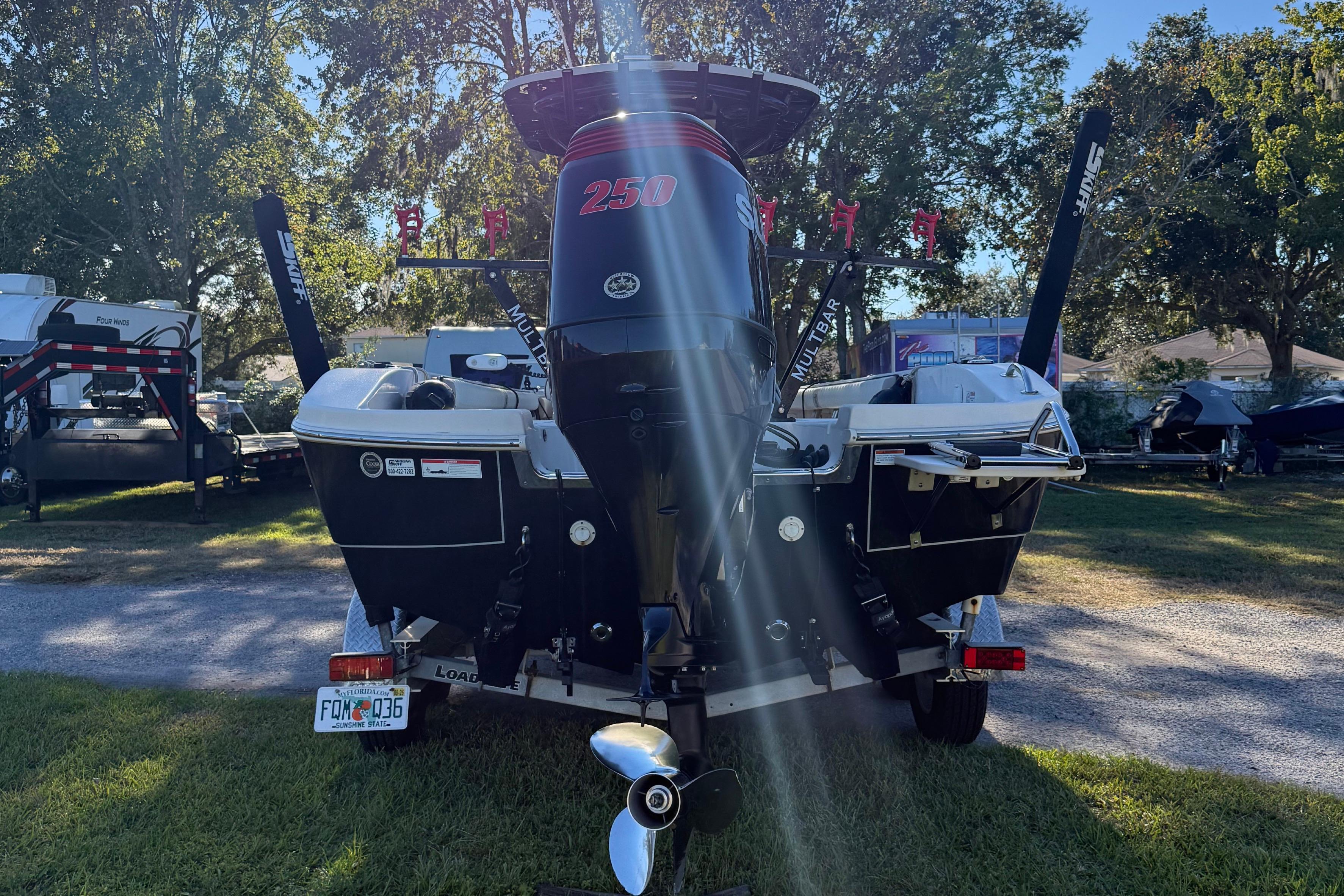 2021 Carolina Skiff 26 Ultra Elite boat with powerful outboard motor in a sunny outdoor setting.
