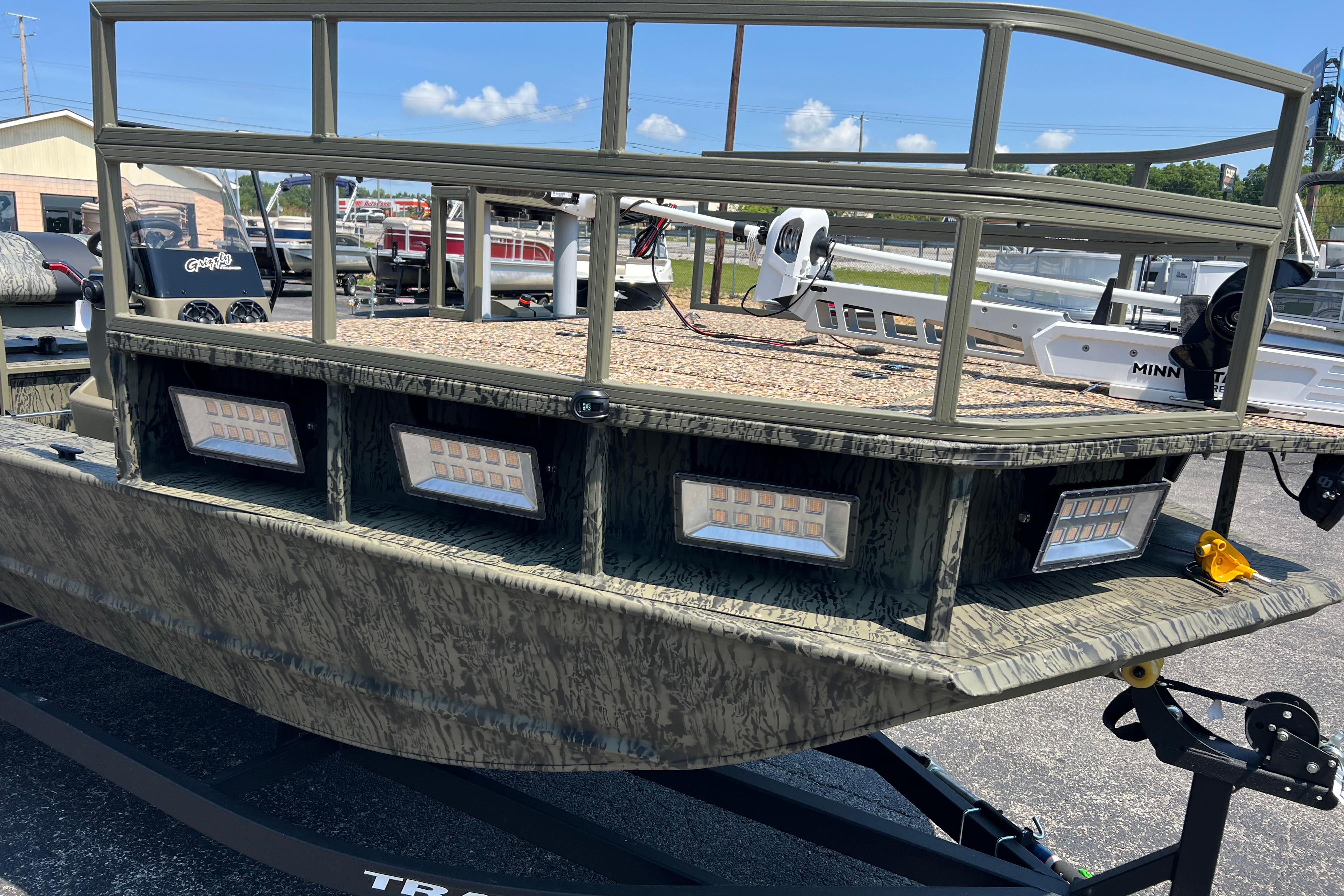 2026 Tracker Grizzly 2072 CC Sportsman Kicker boat with camouflage design and LED lights.