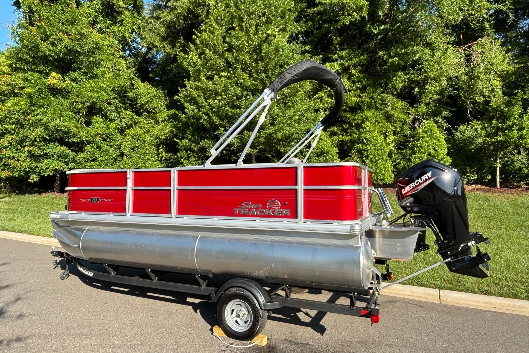 2026 Sun Tracker Party Barge 18 DLX pontoon boat with Mercury outboard motor on trailer.