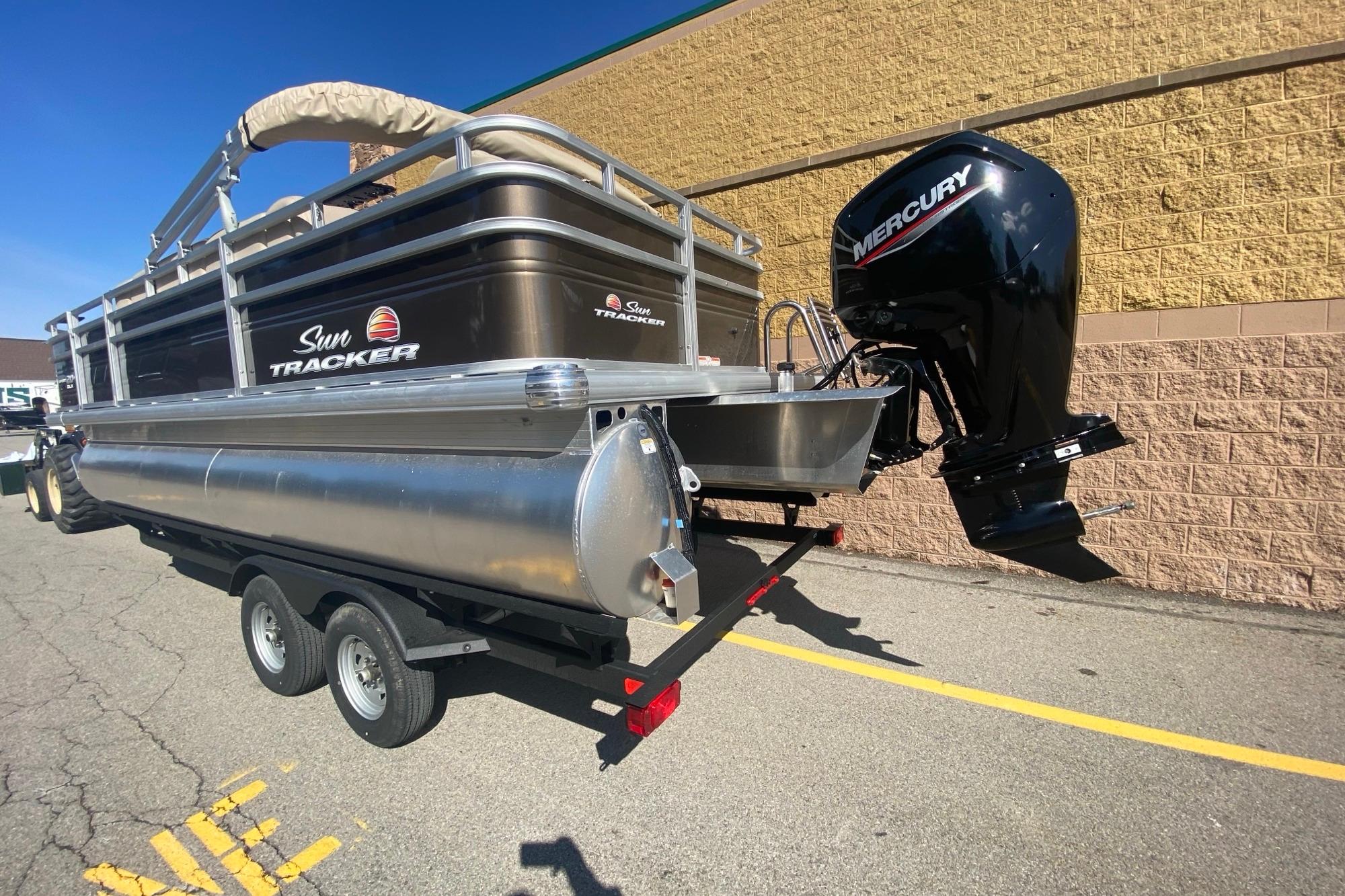 2025 Sun Tracker SportFish 20 DLX pontoon boat with Mercury outboard motor on trailer.