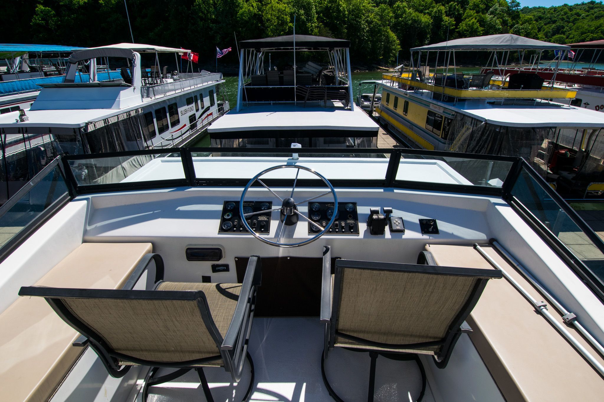 Cockpit of a 2003 Lakeview 16x70 houseboat docked in marina.