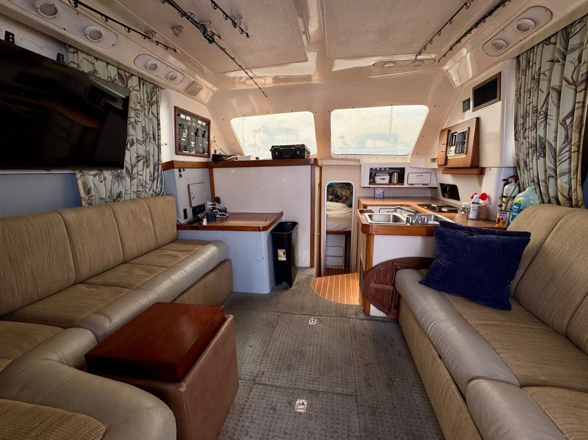 Interior of a 1989 Luhrs 350 Tournament with cozy seating and a small kitchen area.