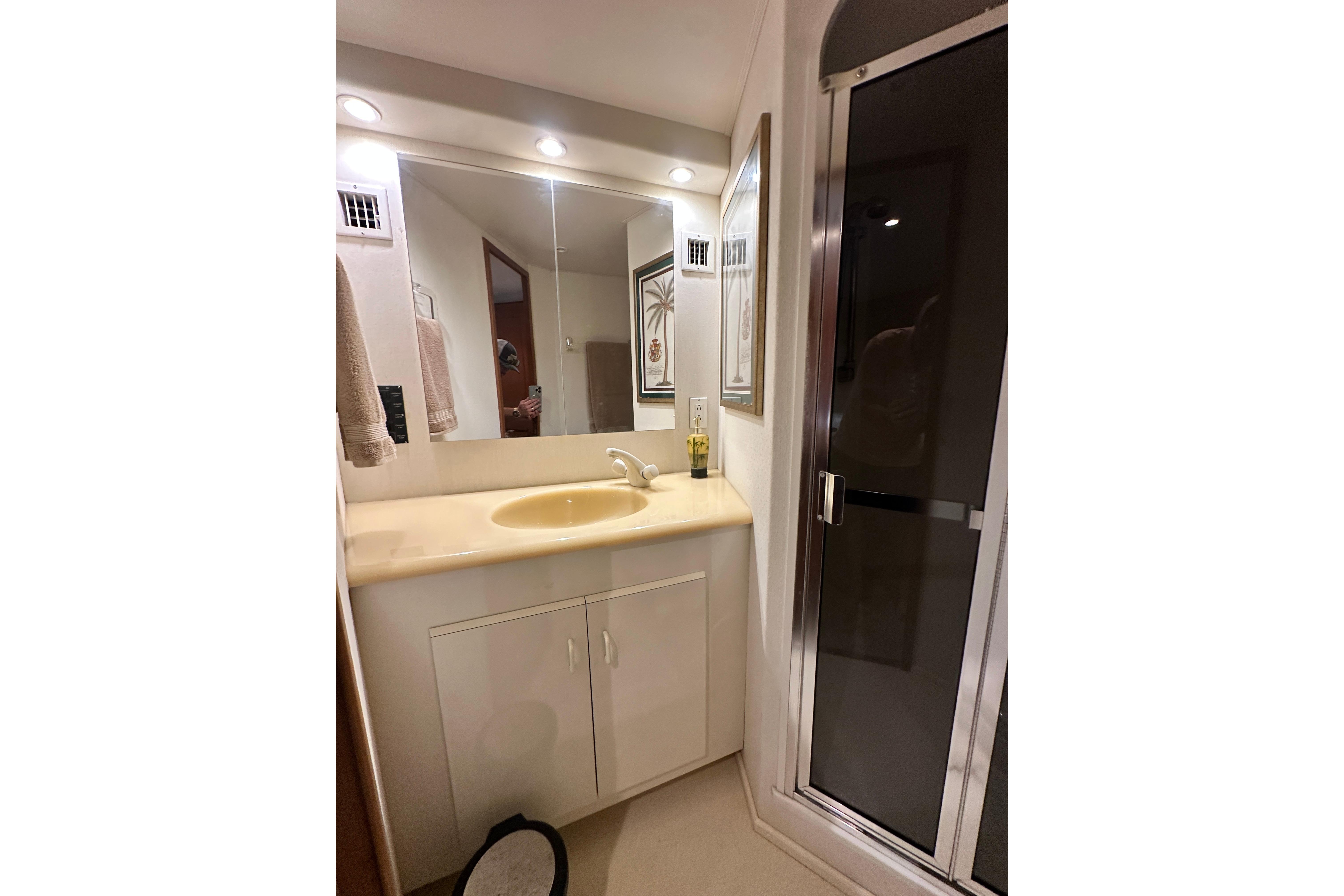 Bathroom vanity with mirror and shower in 1997 Viking 58 Convertible yacht.